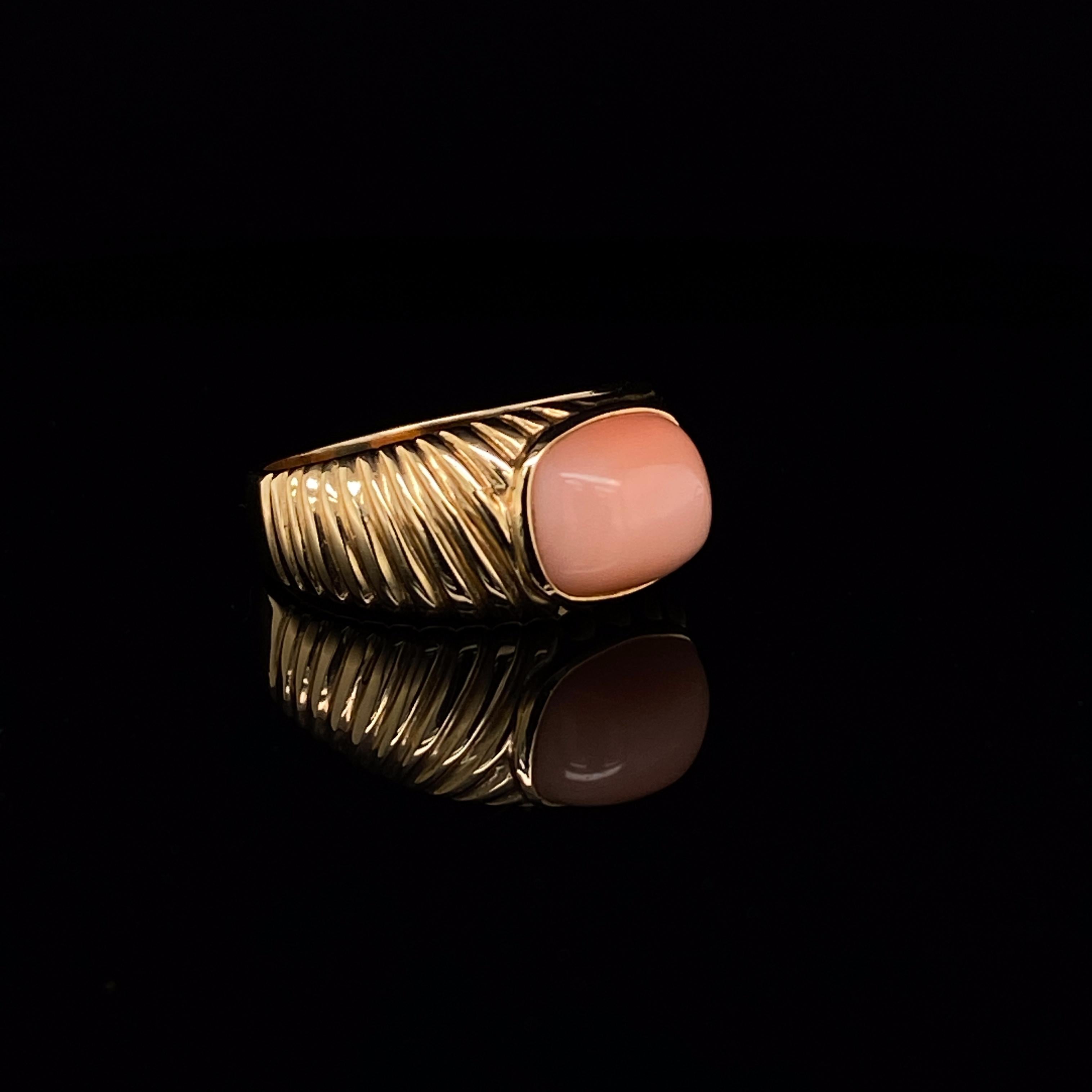 Cartier coral 18 karat yellow gold ring, circa 1950.

A really pretty retro coral ring, by Cartier, the cushion cabochon coral centre bezel set within a ribbed gold design of alternating directions.
signed 
