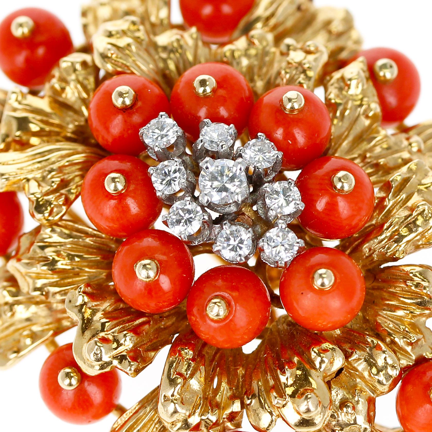A Cartier Coral, Diamonds, and 18 Karat Gold Brooch. There are 9 diamonds and 19 coral beads. The length is 4.50CM and the width is 4.0CM. The total weight is 34.98 grams. The brooch also converts into a pendant. It is truly a work of art and a
