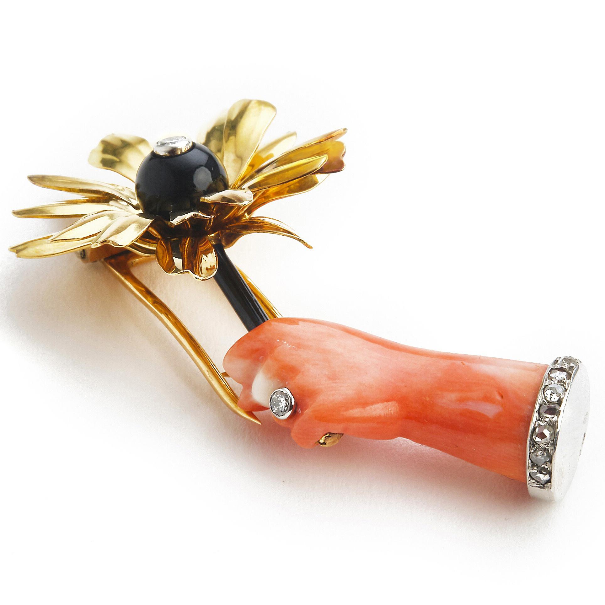 Cartier Hand and Dandelion Flower Pin Brooch, ca. 1937

A delightful piece, where a corallum rubrium hand, wearing a diamond bracelet and an exquisite diamond ring is holding an entremblant dandelion flower made of gold, diamond and black