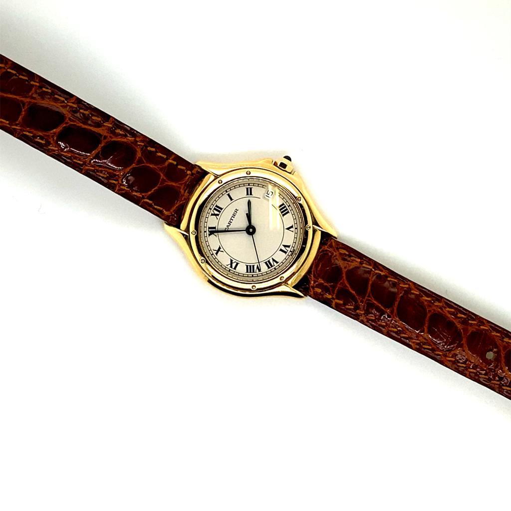 Eine Cartier Cougar Damenuhr in 18 Karat Gelbgold 887921, um 1990.

Diese elegante Armbanduhr mit Quarzwerk und einem Gehäuse aus 18 Karat Gelbgold misst 26 mm x 26 mm. Die achteckige Krone ist mit einem blauen Cabochon besetzt.

Die Armbanduhr mit