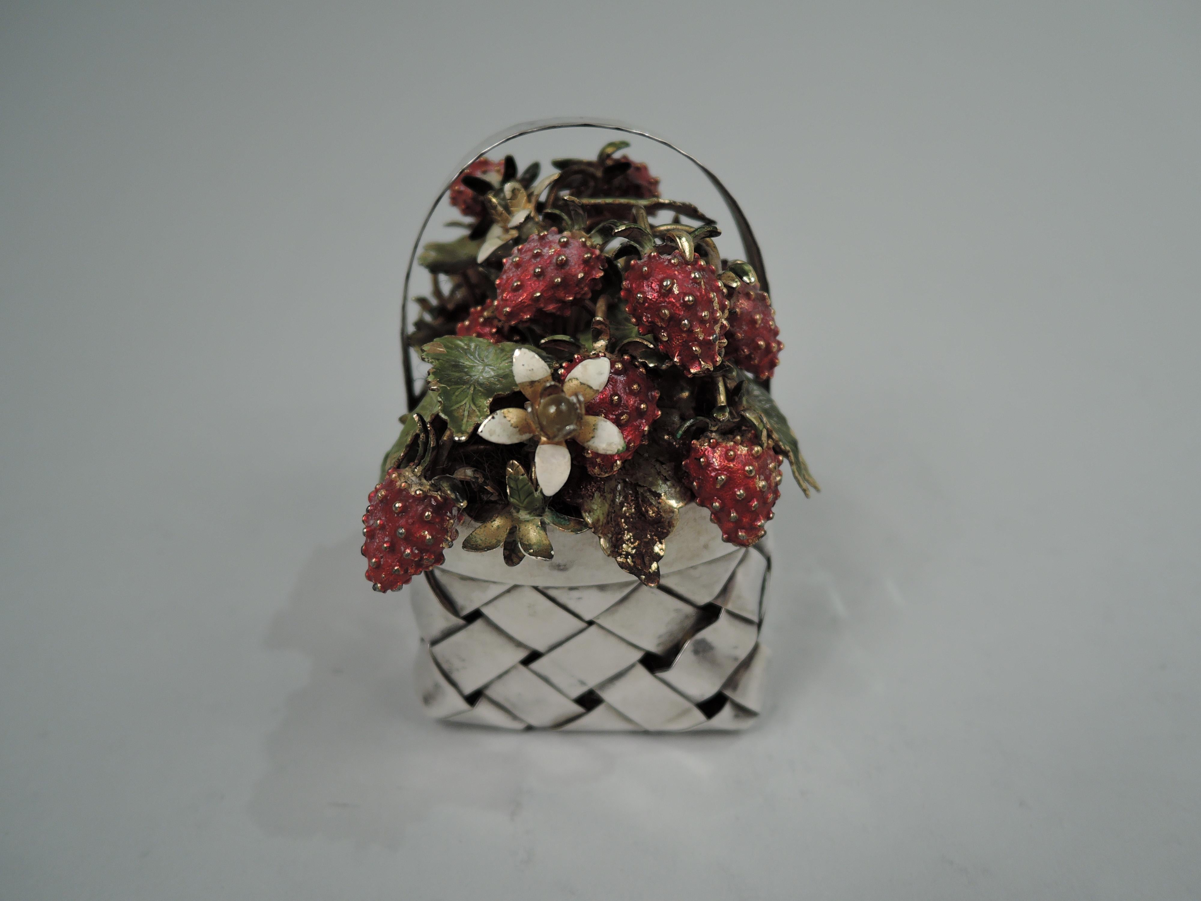 Midcentury Modern sterling silver basket. Retailed by Cartier in New York. Rectangular with straight sides. Plain rim and fixed c-scroll handle with “stitched” rims. Woven strips. Overflowing gilt-enameled strawberry plants with lush fruit and
