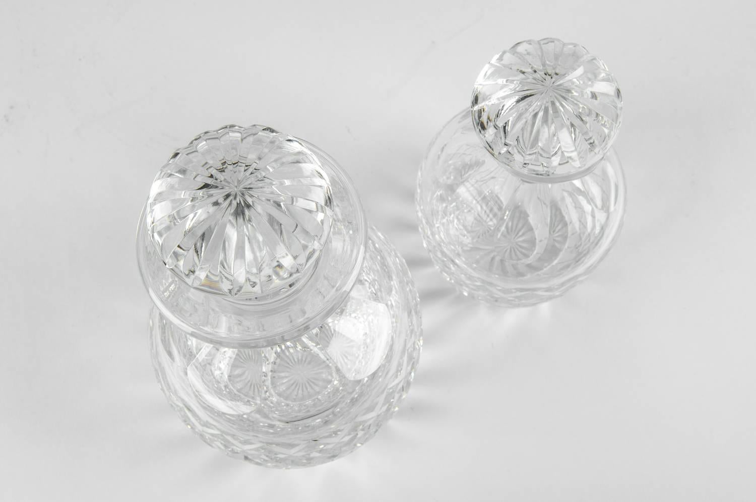 Cartier cut crystal barware pair of decanter. Each decanter is in excellent condition. Maker's mark undersigned on each one. Each decanter stopper is numbered .The taller measure about 9 inches high x 5 inches diameter. The smaller decanter measure