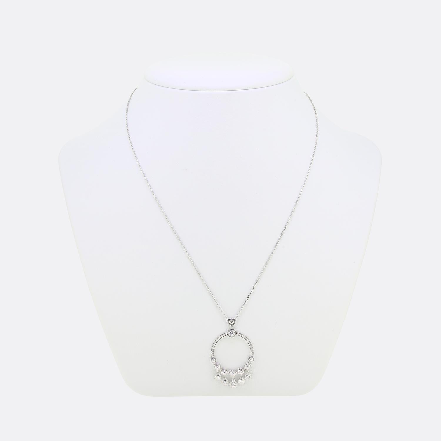 Voici un ravissant collier de la maison de joaillerie de renommée mondiale Cartier. Ce pendentif fait partie de la collection emblématique d'Amour et présente 5 diamants sertis en chaton qui pendent librement à partir d'un cadre circulaire ouvert