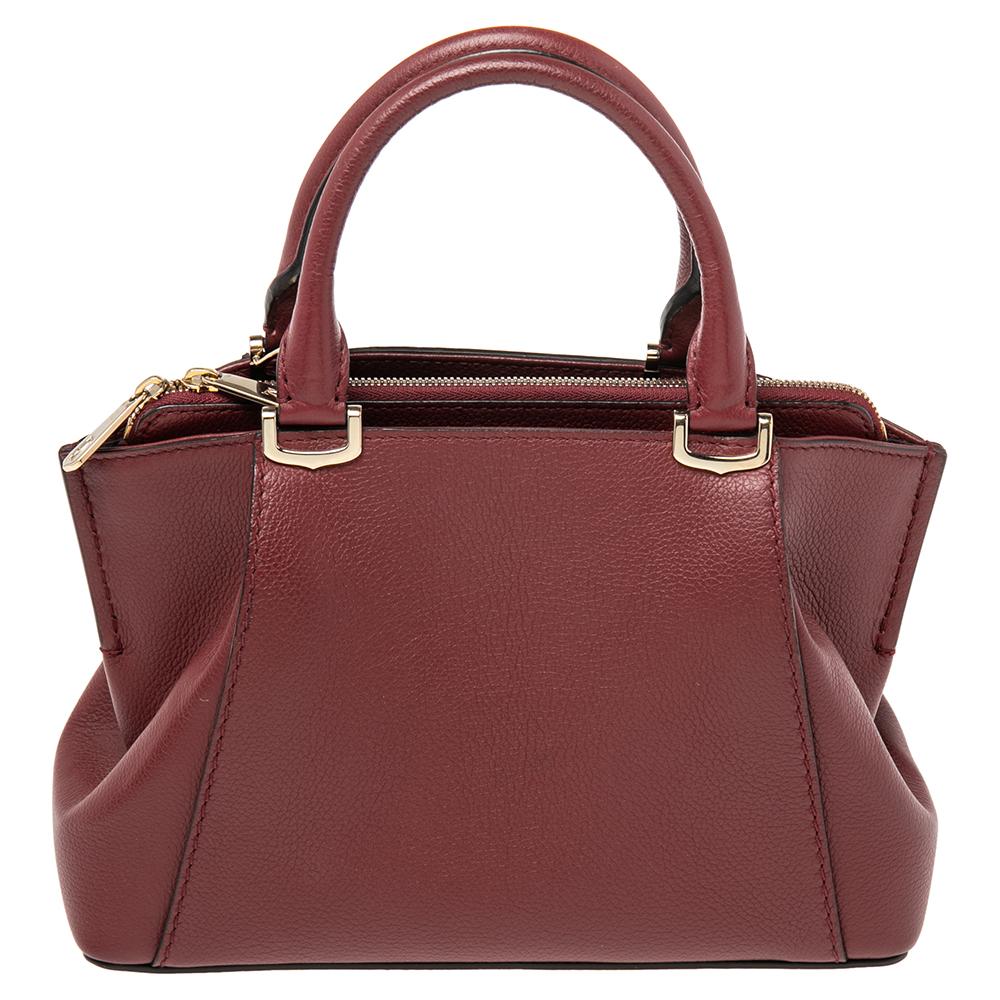 The C de Cartier is a collection from Cartier that appeases your sophisticated personality just right. This bag in dark red is crafted with leather and features gold-tone C motif handle links. The exterior of the bag has brand details on the front