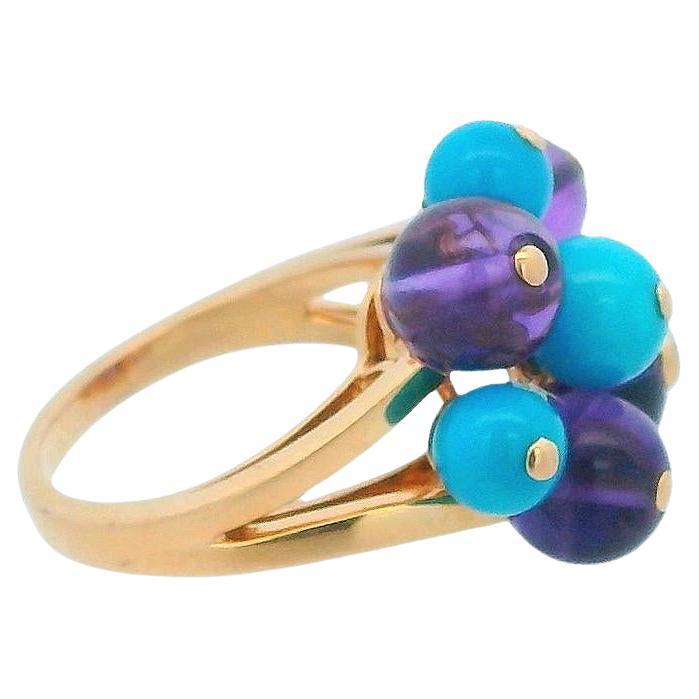 La bague moyenne Délice de Goya de Cartier est réalisée en or jaune 18 carats et comporte des diamants, une améthyste et une turquoise. Le design consiste en une alternance de perles d'améthyste et de turquoise, mises en valeur par un diamant taille