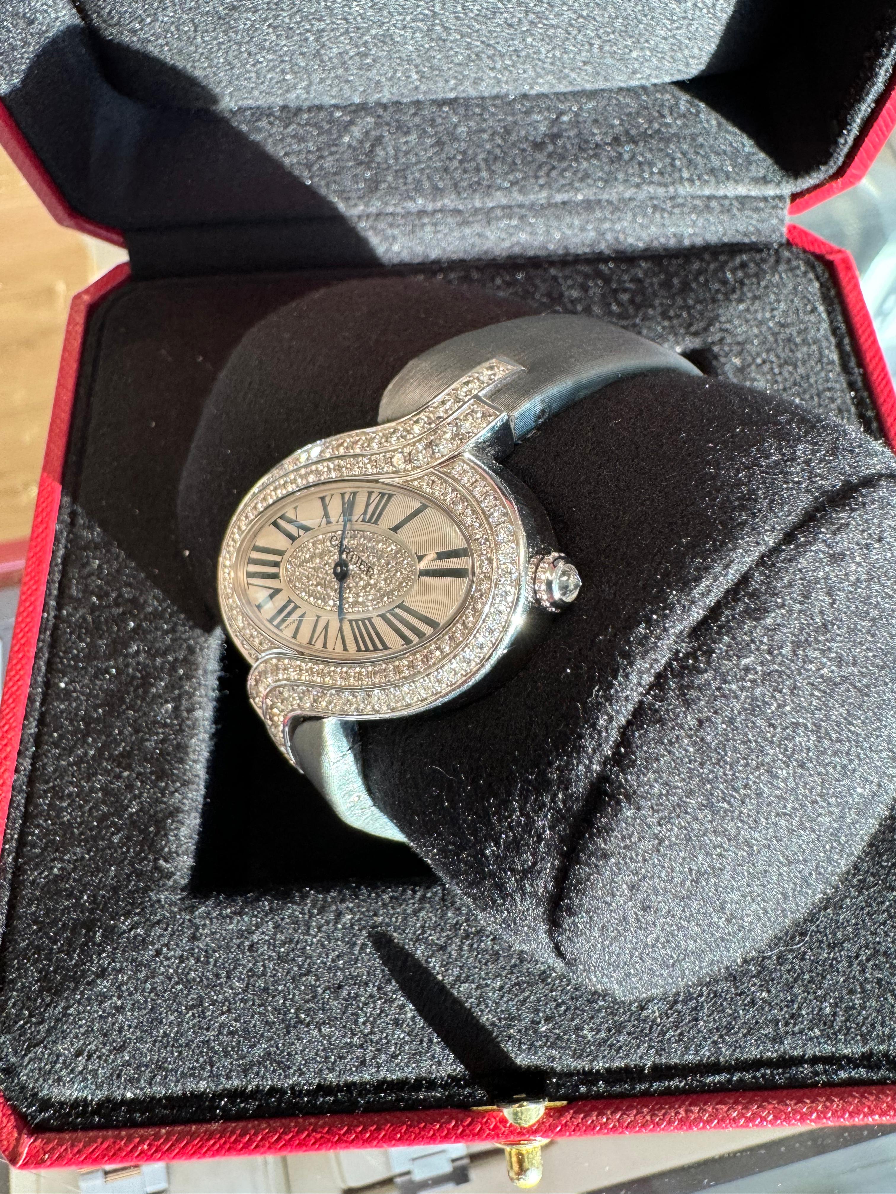 Montre Cartier Delices de Cartier en diamants, or blanc 18 carats, bracelet en satin.
Sur demande, une évaluation numérique actualisée par un GIA G.G. est fournie après l'achat. Veuillez nous contacter pour toute question. Merci.

Numéro