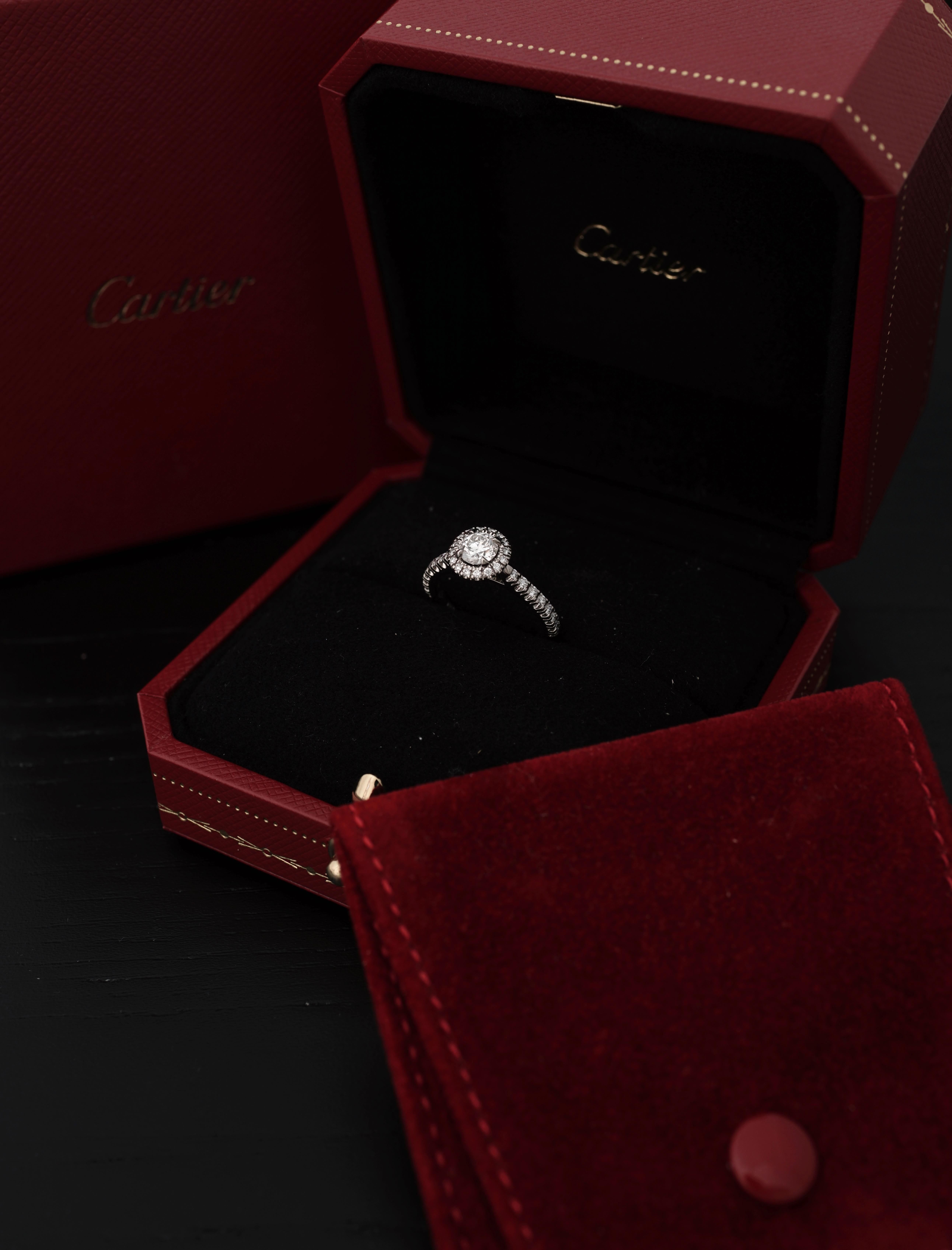 Cartier, Desitnée Solitaire,
Talla brillante redonda
Certificado GIA 0,42 Quilates, Color G y Claridad VS1 y calidad Triple X.
Montada en Platino 950/1000 y engastada con un halo de diamantes talla brillante. 
Firmado Cartier y numerado. Talla 47