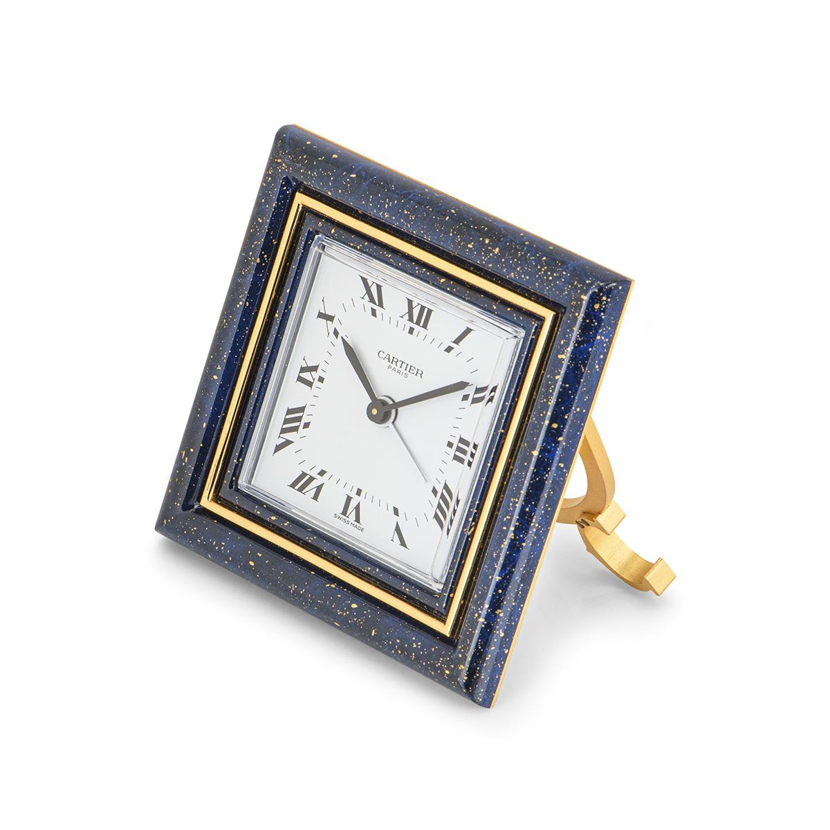Eine 75-mm-Tischuhr aus Messing von Cartier. Sie hat ein weißes Zifferblatt mit römischen Ziffern:: eine Lünette aus Lapis-Email und eine äußere Lünette aus Messing. Das Messinggehäuse ist ebenfalls mit Lapislazuli besetzt. Ausgestattet mit