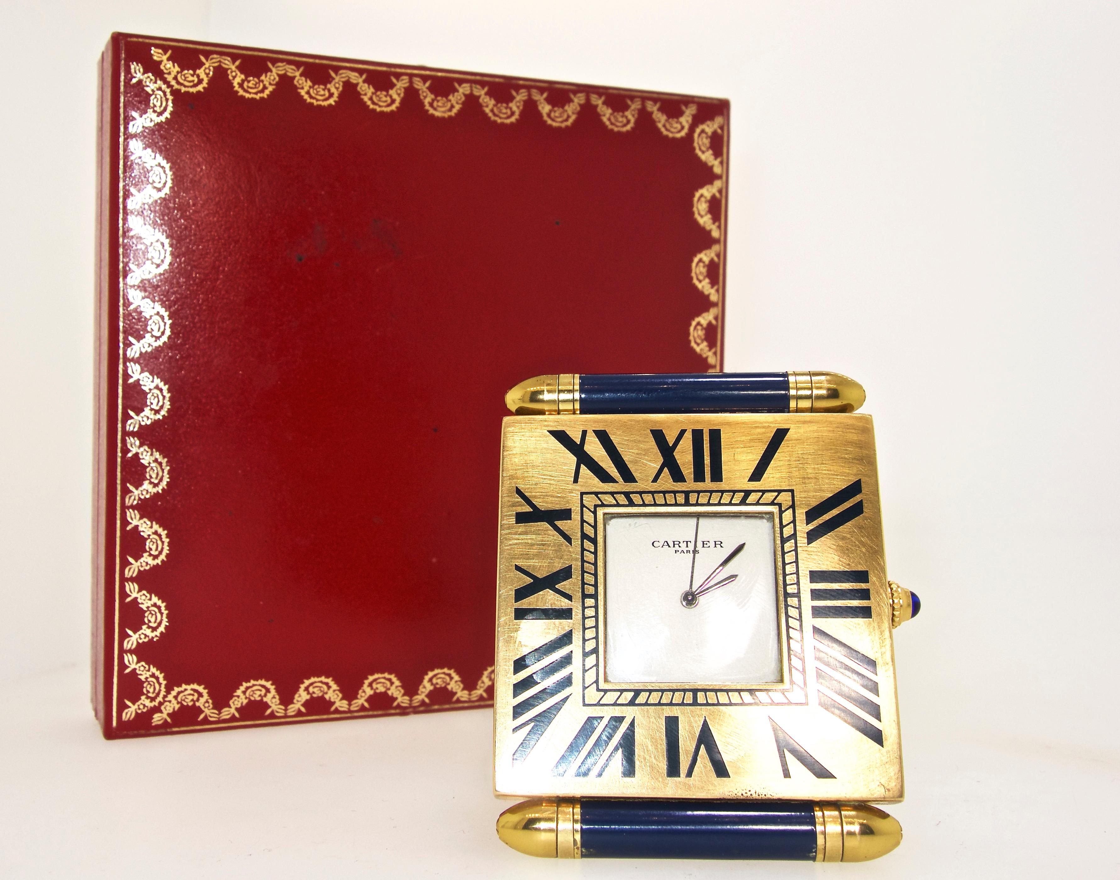 Cartier has made a useful small, easy to travel, desk clock in gold plate with blue enamel.  It is a quartz, recently serviced, and in good working condition.  It folds nicely together when not in use.  Signed on the dial and on the verso, also