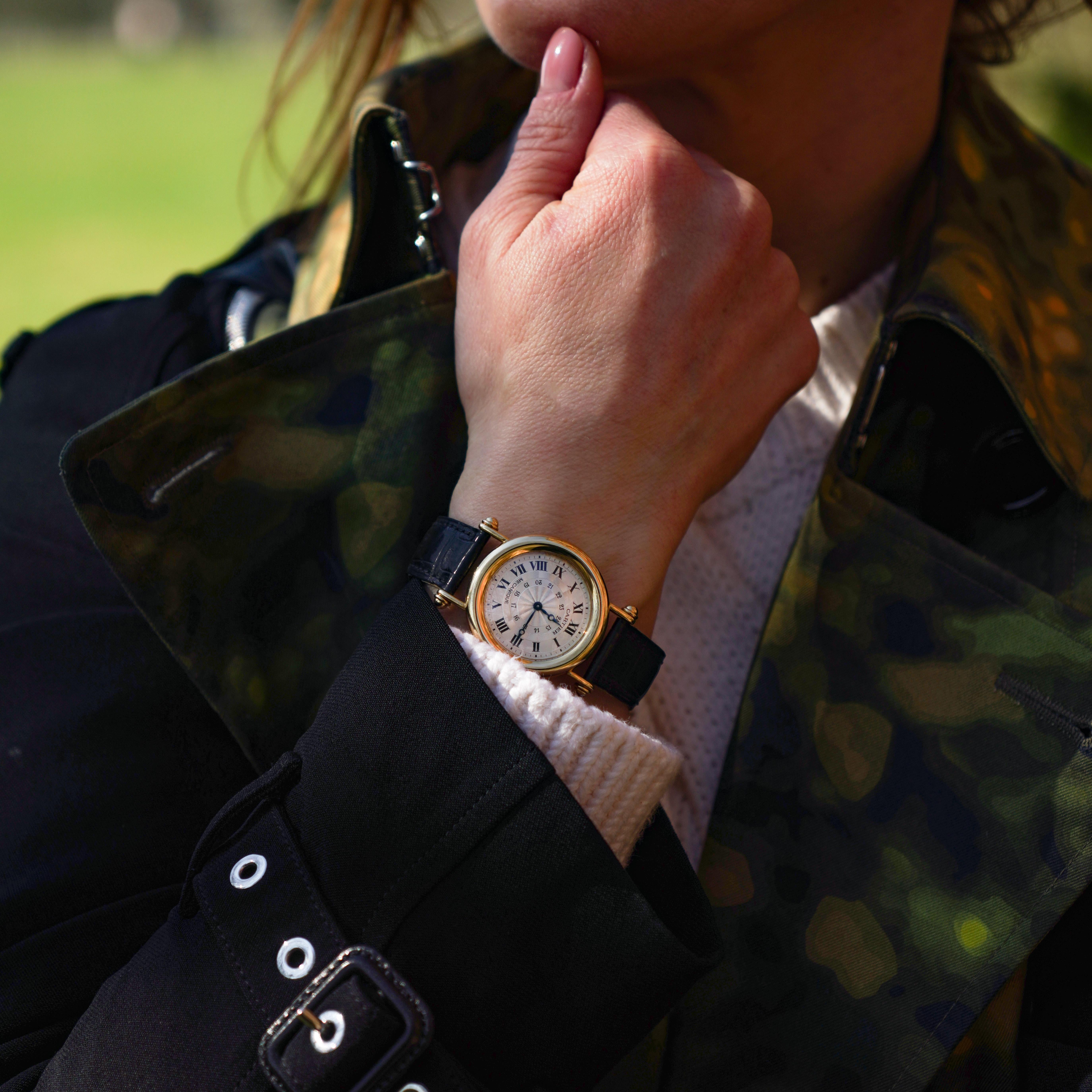 A distinguished Cartier Diabolo wristwatch, crafted in 18K yellow gold, featuring a manual wind mechanical movement. This elegant timepiece showcases a silver guilloché dial with black Roman numerals, an inner 24-hour scale, and the Cartier
