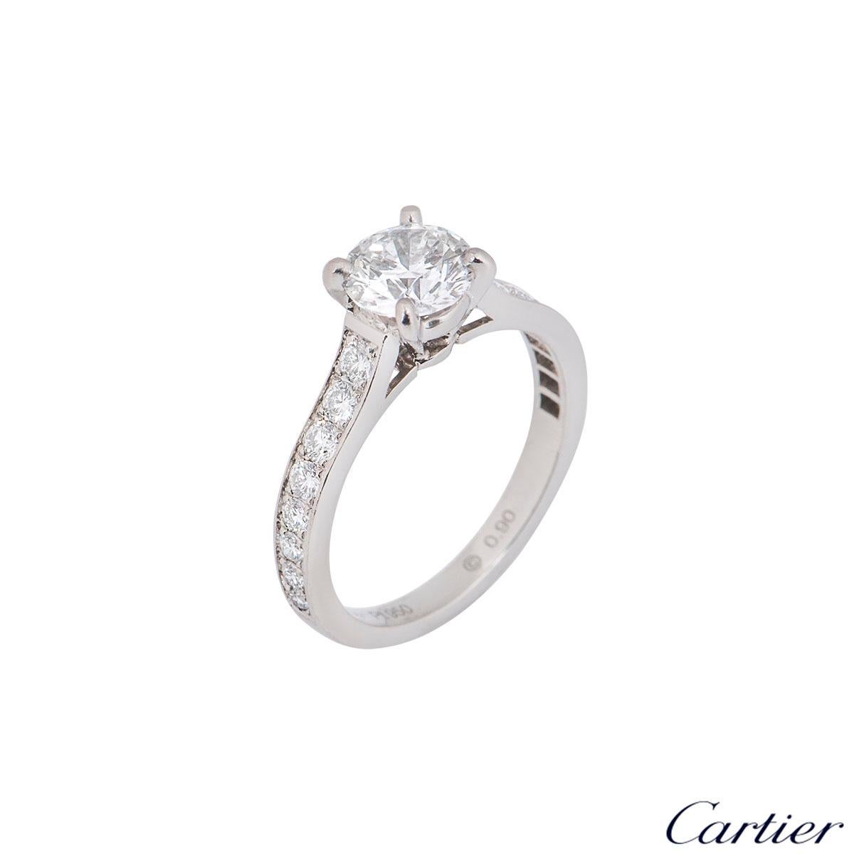 A stunning platinum Cartier diamond engagement ring from the 1895 solitaire collection. The ring comprises of a round brilliant cut diamond in a four claw setting with a weight of 0.90ct, E colour and VS2 clarity with 16 round brilliant cut diamonds