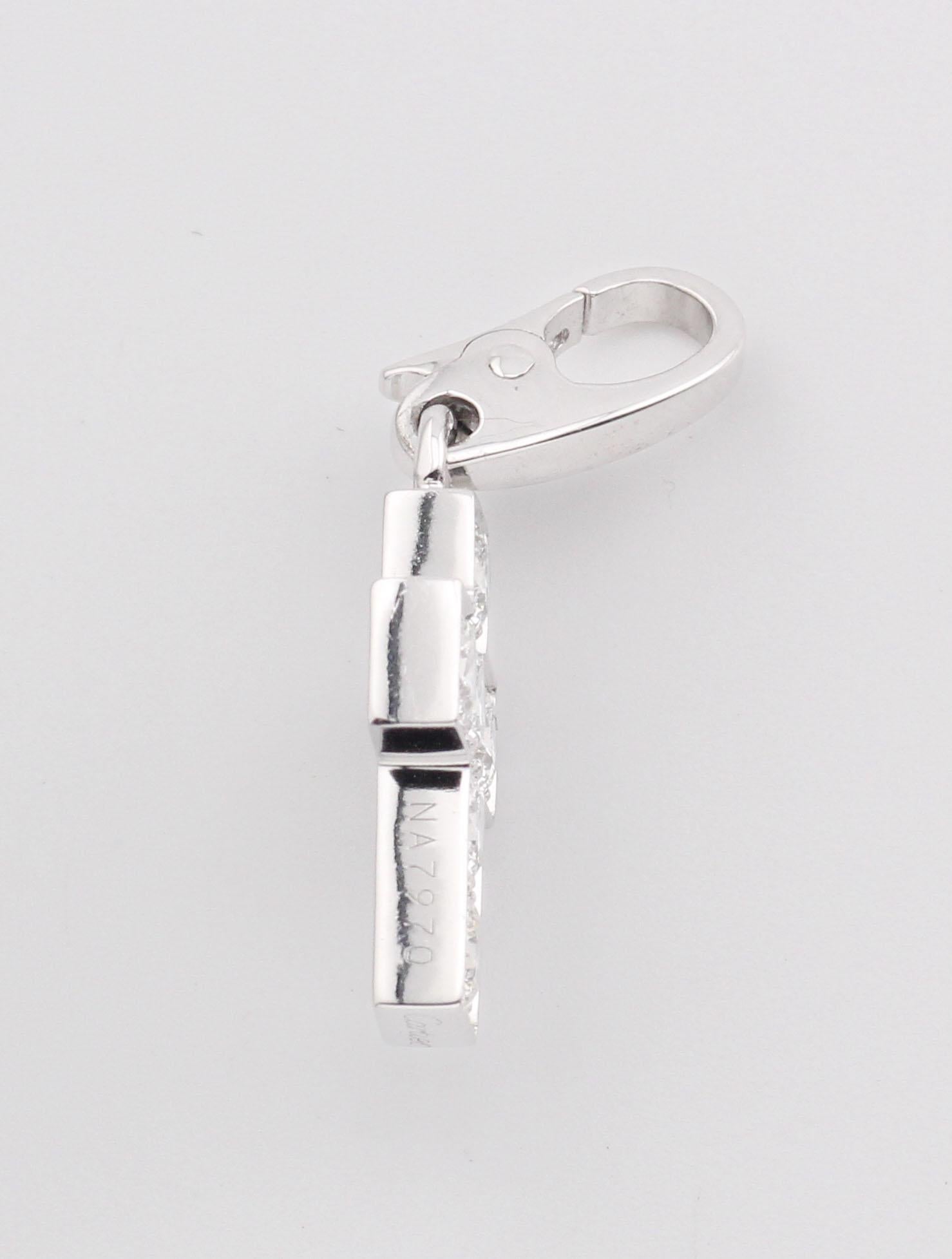 Le pendentif breloque croix en or blanc 18 carats avec diamants de Cartier est une pièce raffinée et élégante qui illustre l'esthétique intemporelle de Cartier. Fabriqué en or blanc 18K poli, le pendentif présente une croix épurée et minimaliste,