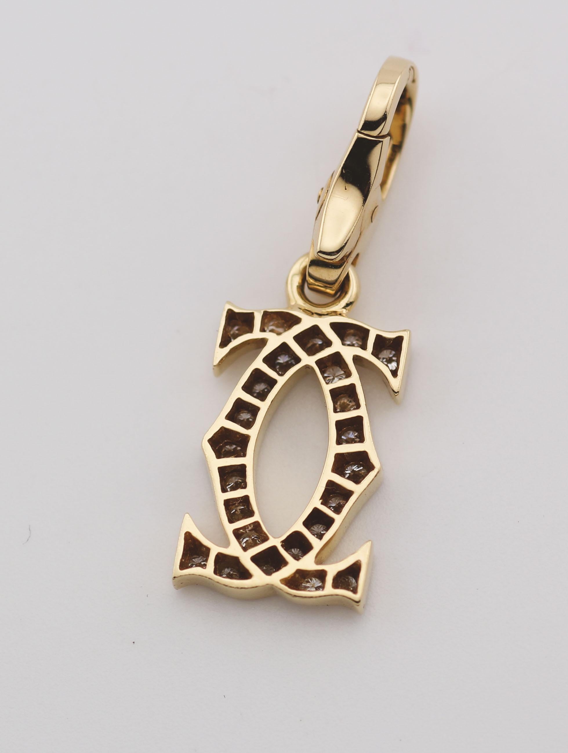 Élevez votre style avec la breloque double C-Logo en or jaune 18 carats et diamants de Cartier, symbole d'élégance et de luxe intemporels. Cette breloque exquise associe harmonieusement le design emblématique de Cartier à l'éclat des diamants et à