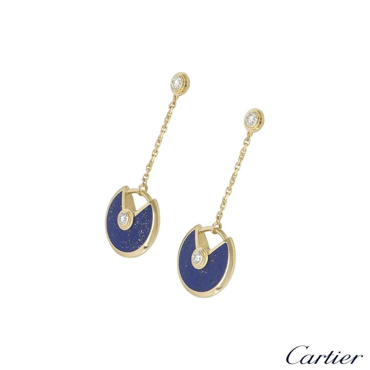 A pair of 18k yellow gold earrings by Cartier from the Amulette de Cartier collection. The earrings are composed of a single round brilliant cut diamond, suspending a lapis lazuli disk, with another round brilliant cut diamond in the centre. The
