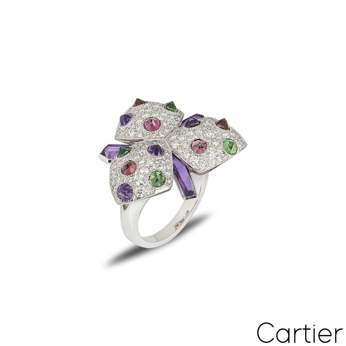 A striking dress ring from the Caresse d'Orchidées collection by Cartier. The ring features pave diamonds and reverse set amethysts, pink tourmalines and tsavorites. The diamonds have a total weight of approximately 0.40ct and the gemstones have an