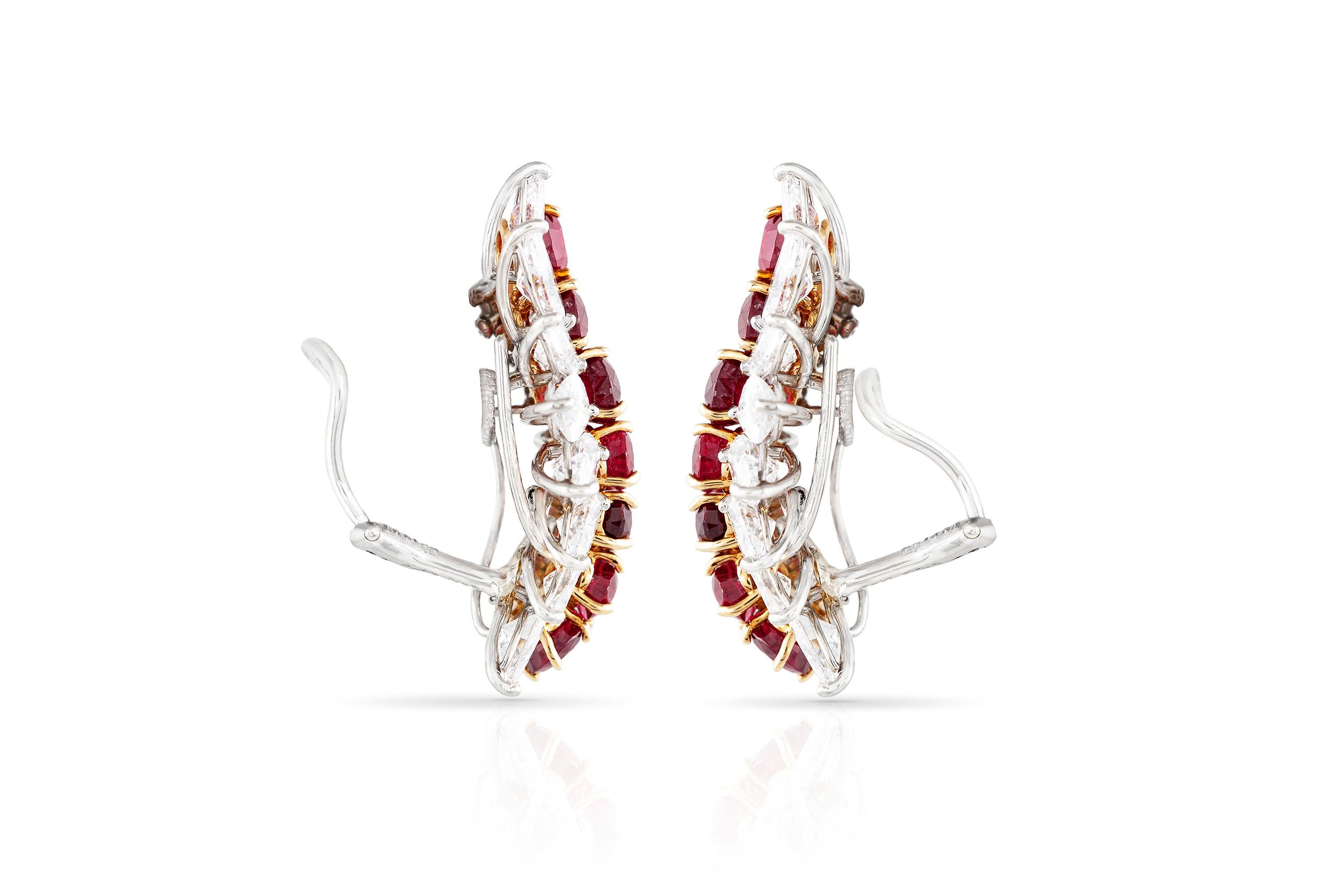 Cluster ear clip earrings, finely crafted in platinum and 18 k yellow gold, featuring 14 Burmese rubies, weighing a total of 12.46 carats, surrounded by brilliant and marquise cut diamonds, weighing a total of 11.11 carats. Signed and numbered by