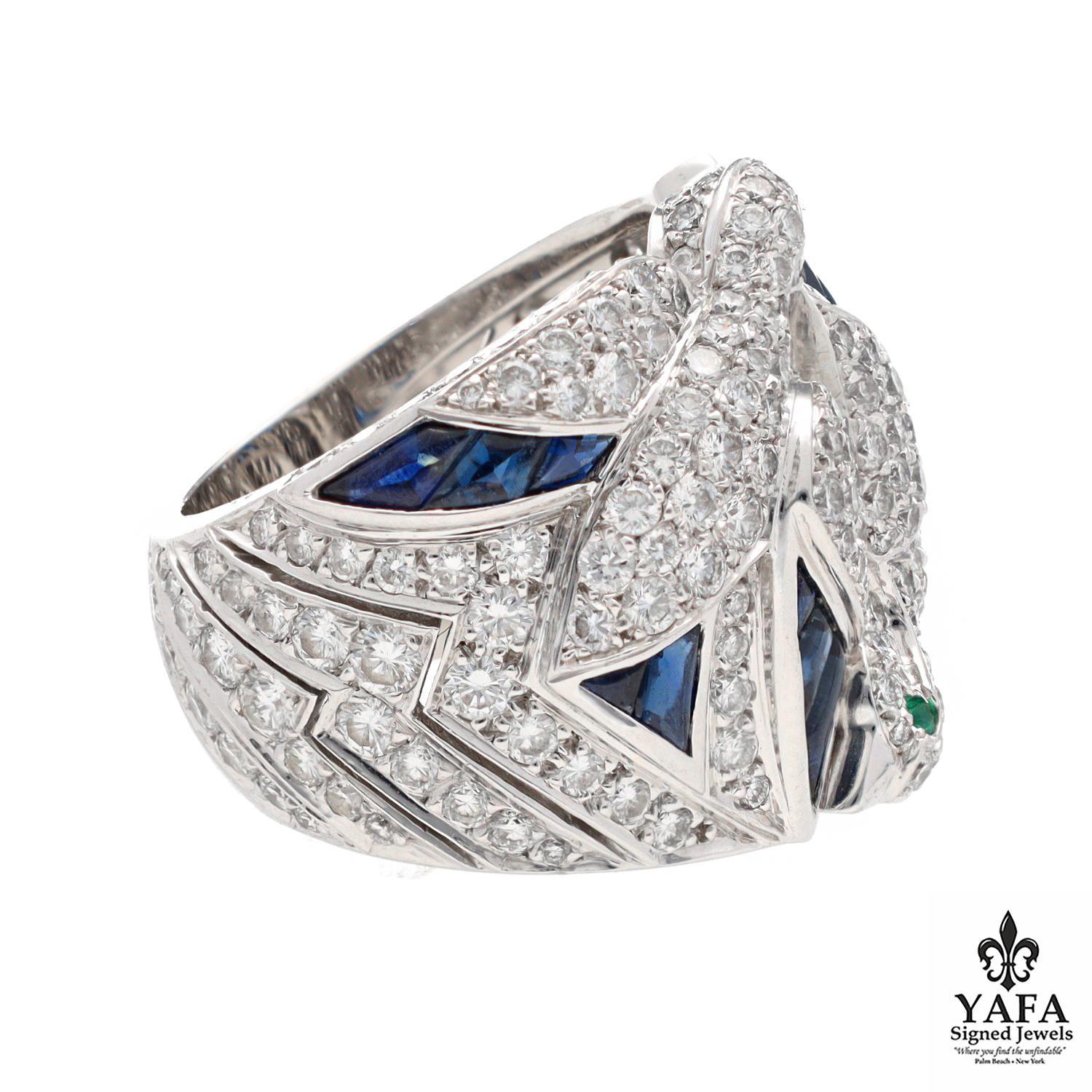 Depicting a Pair Of Birds in Flight, This Fanciful Ring is Set with Pave Diamonds and Accented with Buff-Top Calibre-Cut Sapphires and Round Emerald Eyes.

French Assay Marks
Signed - Cartier