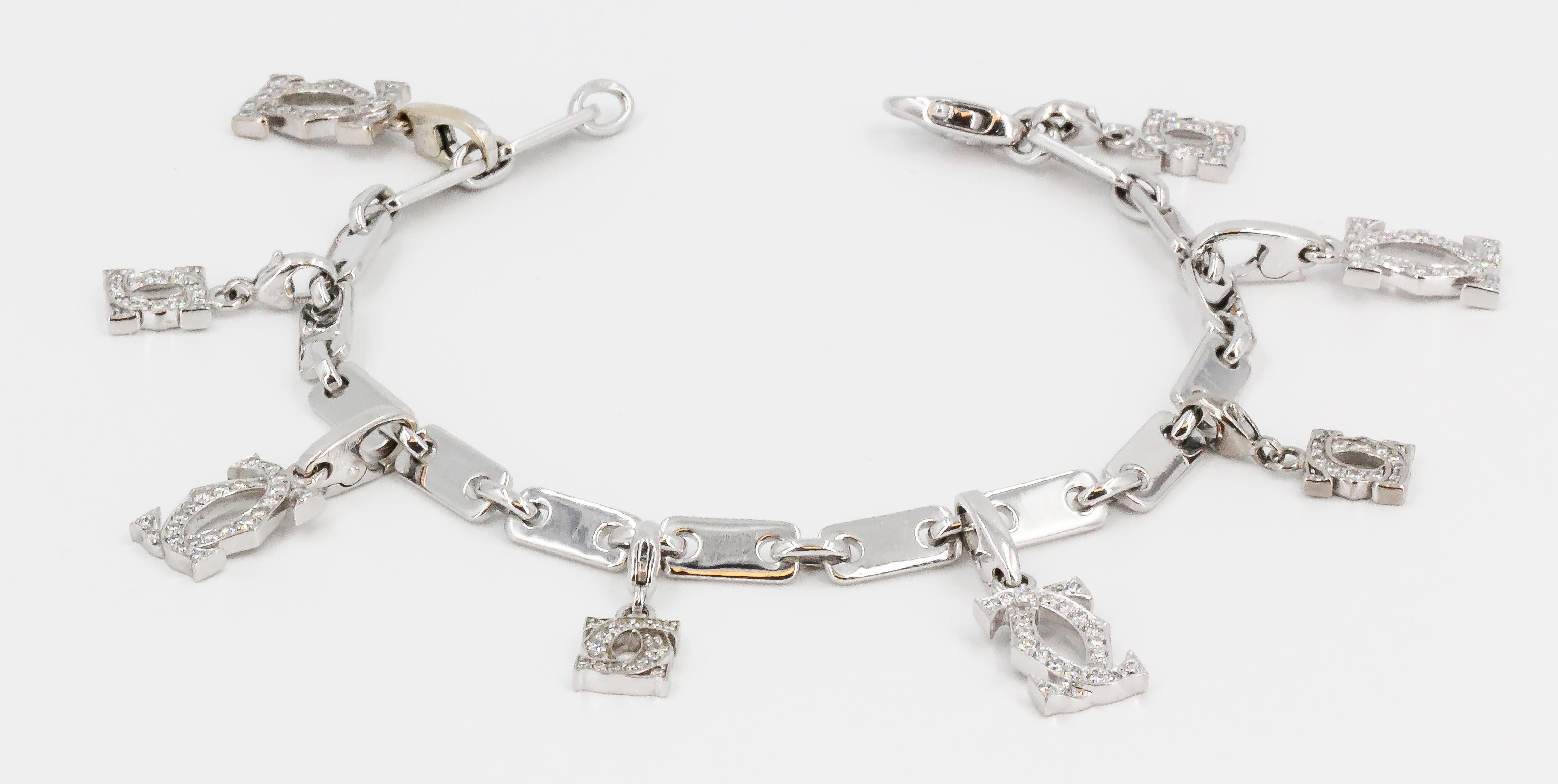 Fine diamond and 18K white gold charm bracelet by Cartier. It features a link bracelet adorned with 8 Cartier double 