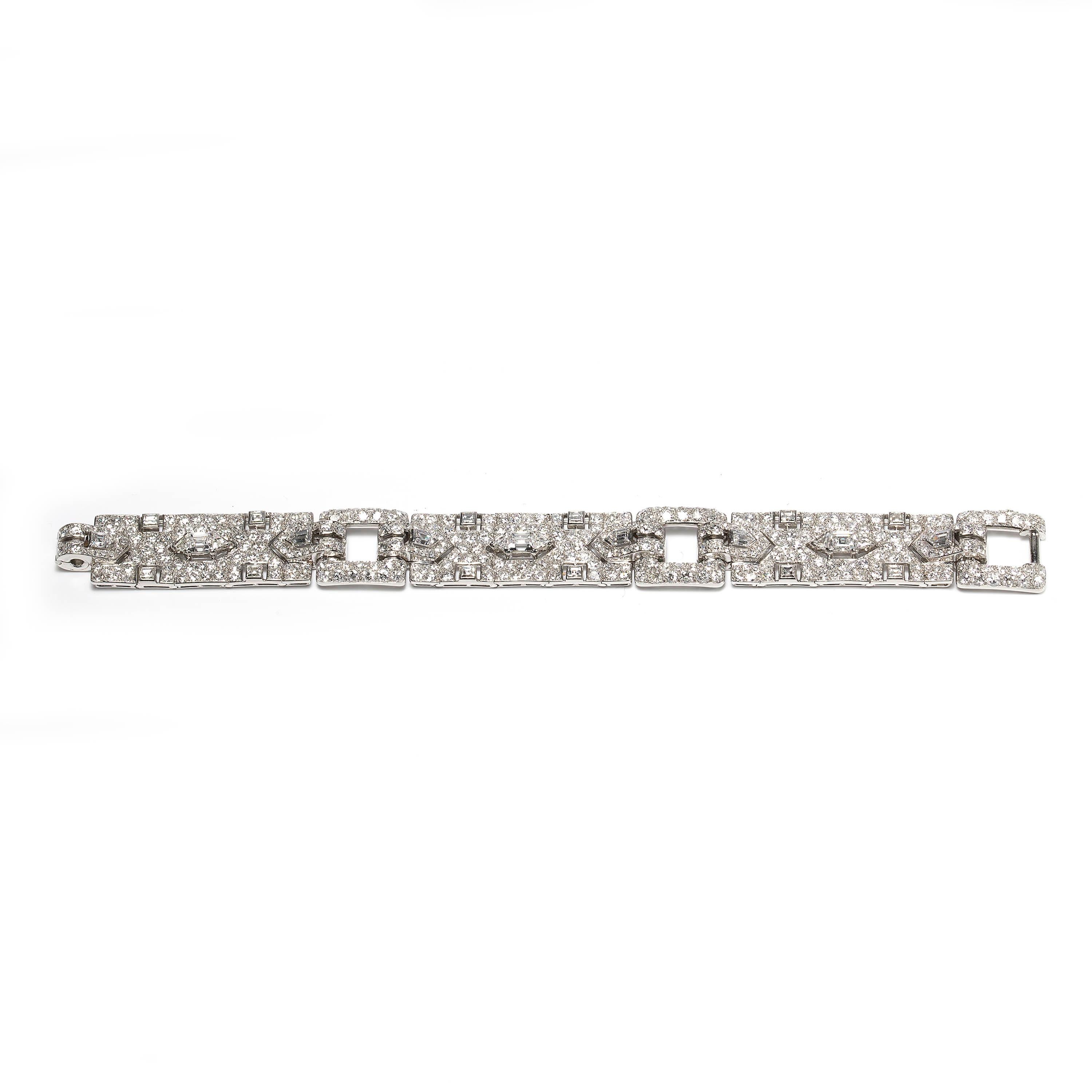 A vintage Cartier bracelet, comprised of three panels, each set with a central trap-cut diamond flanked by triangular and fancy-cut diamonds, with transitional brilliant-cut and single-cut diamonds surrounds, all mounted in platinum. The clasp is
