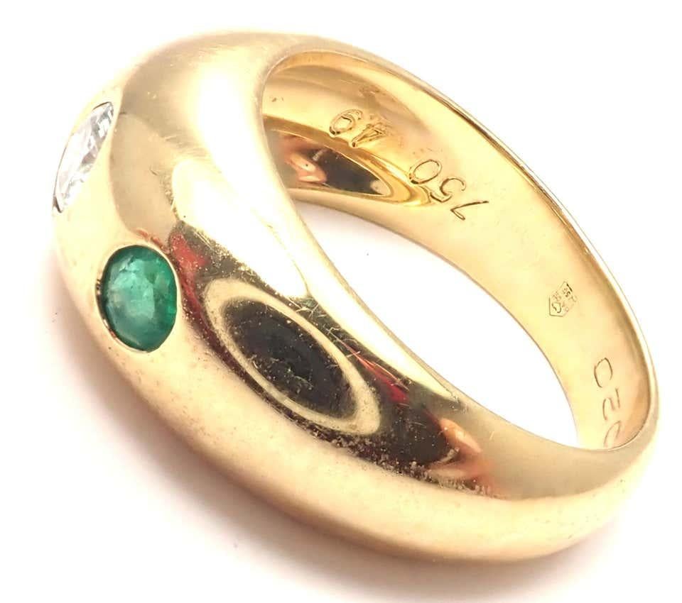 18k Yellow Gold And Diamond Emerald Band Ring by Cartier. 
With 1 diamonds VVS1 clarity, E color 
2 emeralds
Measurements: 
Weight: 7.3 grams
Width: 8mm
Ring Size: European 49, US 4 3/4
Stamped Hallmarks: 750 Cartier 49
*Free Shipping within the