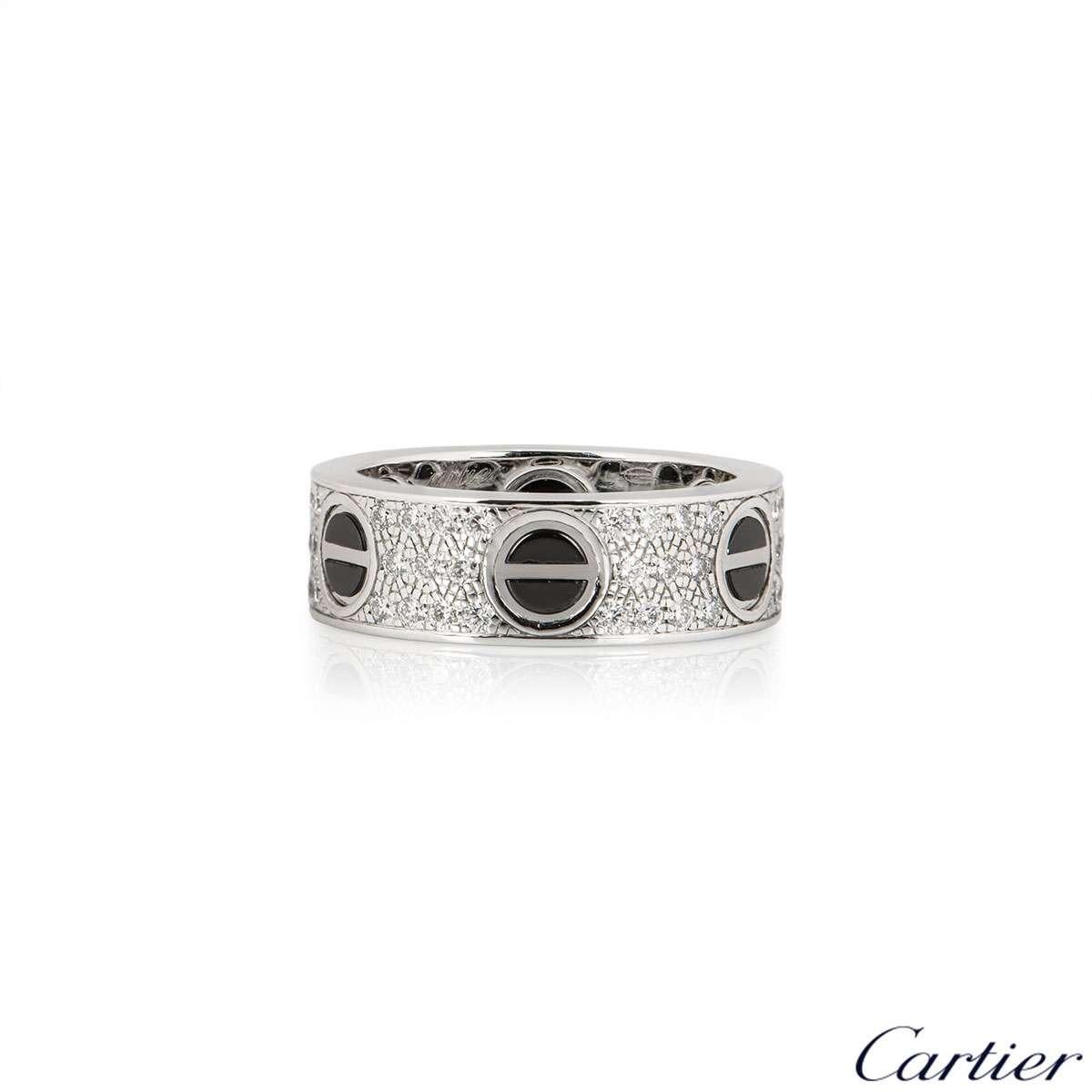 An 18k white gold diamond set Love ring by Cartier. The ring features the classic screw motif, featuring a ceramic inlay, around the outer edge and has 66 pave set, round brilliant cut diamonds set between each screw, totalling 0.74ct. The 6mm wide