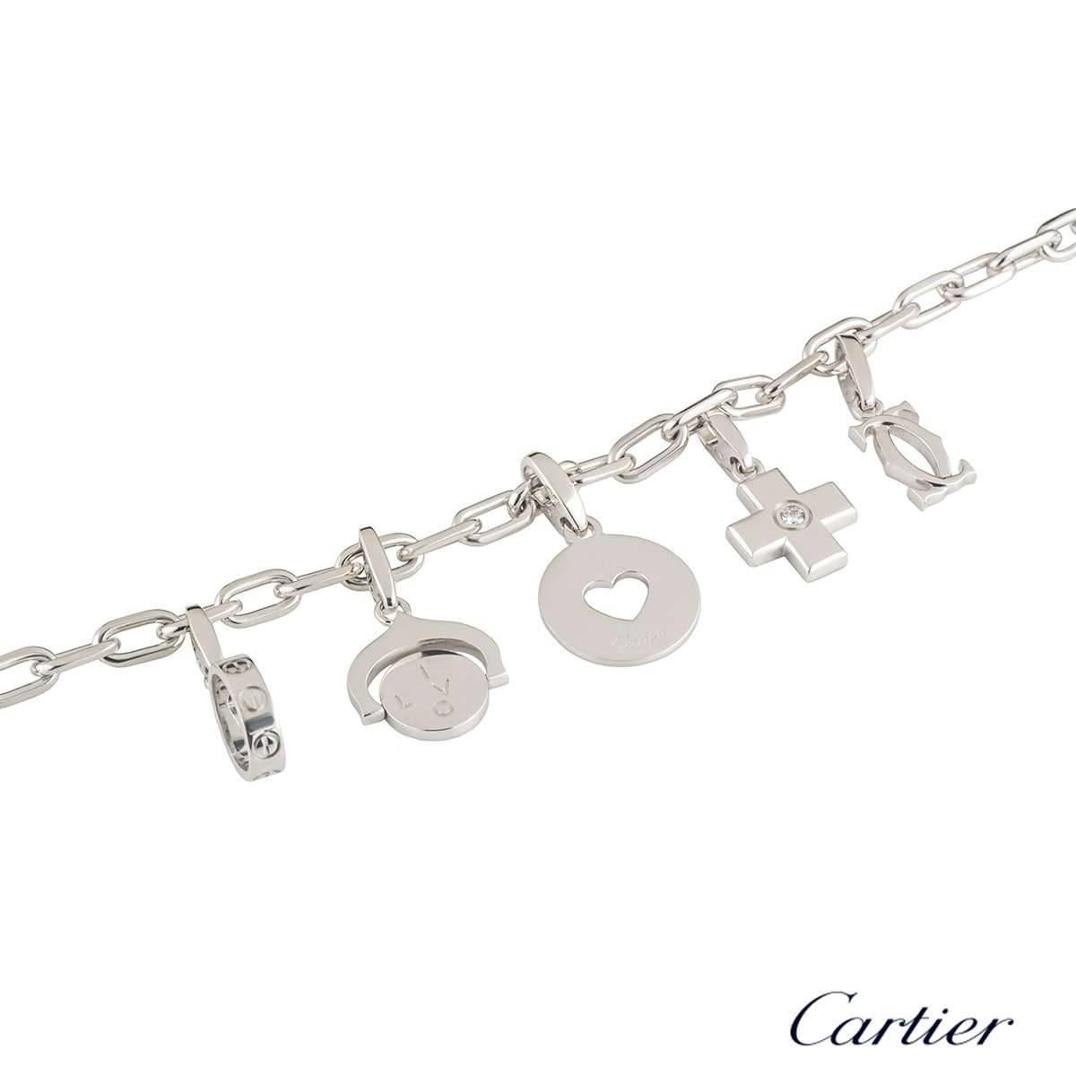 A unique 18k white gold Cartier charm bracelet. The bracelet comprises of a white gold flat cable chain with 5 Cartier charms. The first charm is a circular motif hanging off a anchored bail with letters on either side, spelling out 'I LOVE YOU'.