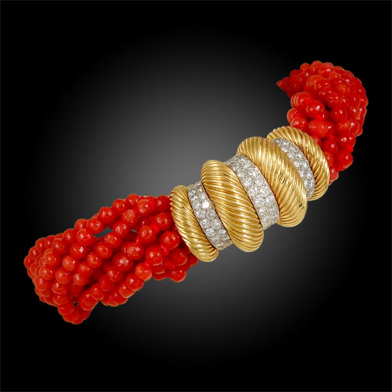 CARTIER Coral Diamond Torsade Retro Bracelet in 18k Yellow Gold.

A gorgeous retro Cartier bracelet of torsade design, comprised of ten strands of vibrant coral beads secured with a fluted yellow gold clasp featuring brilliant round cut diamond