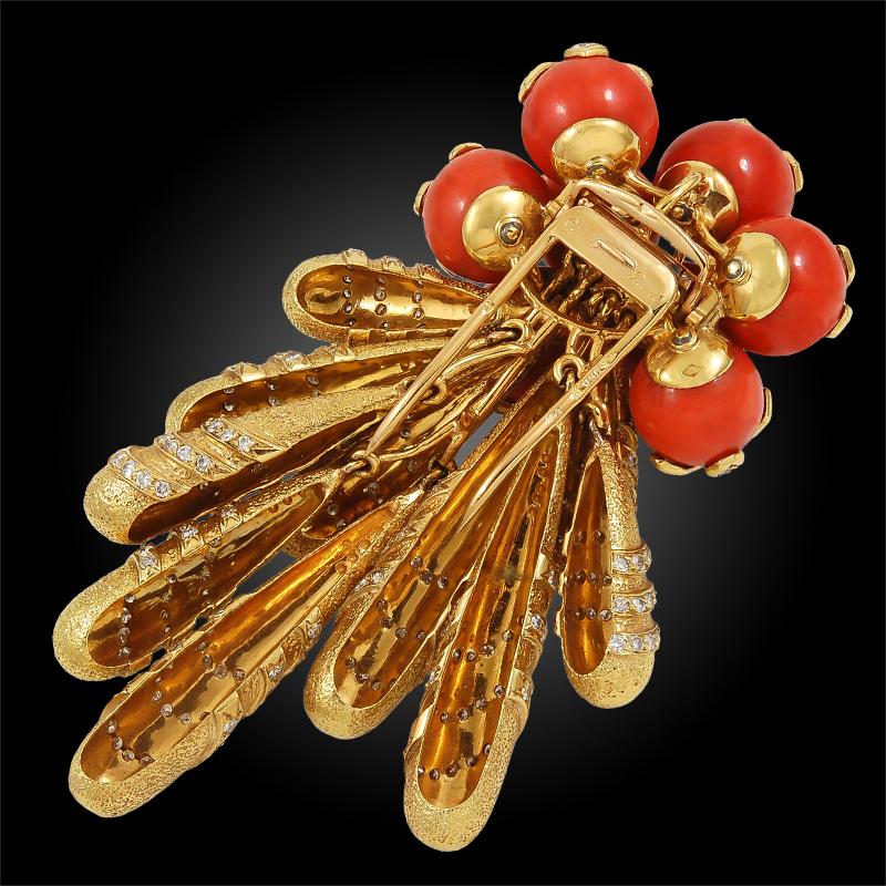 Comprising a unique and extravagant Cartier moveable brooch from the 1960s, finely crafted in 18k yellow gold and adorned with diamonds and vibrant coral orbs.
 Signed Cartier. Made in Paris