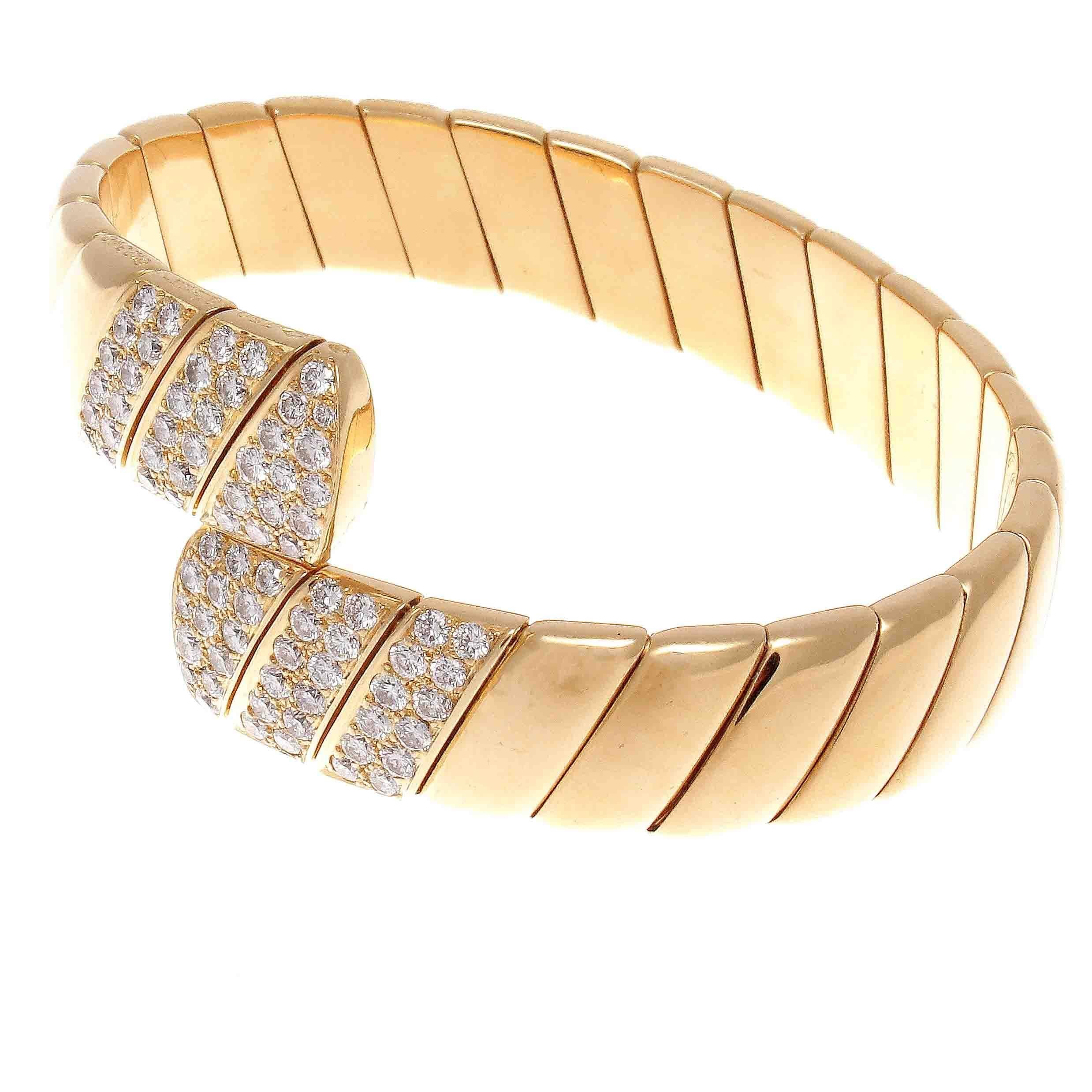 Cartier's undeniable style has reigned supreme for multiple centuries. Featuring flowing sections of glistening 18k yellow gold ending in radiating sections of brilliant white diamonds that are D-E color, VVS clarity. Signed Cartier, numbered and