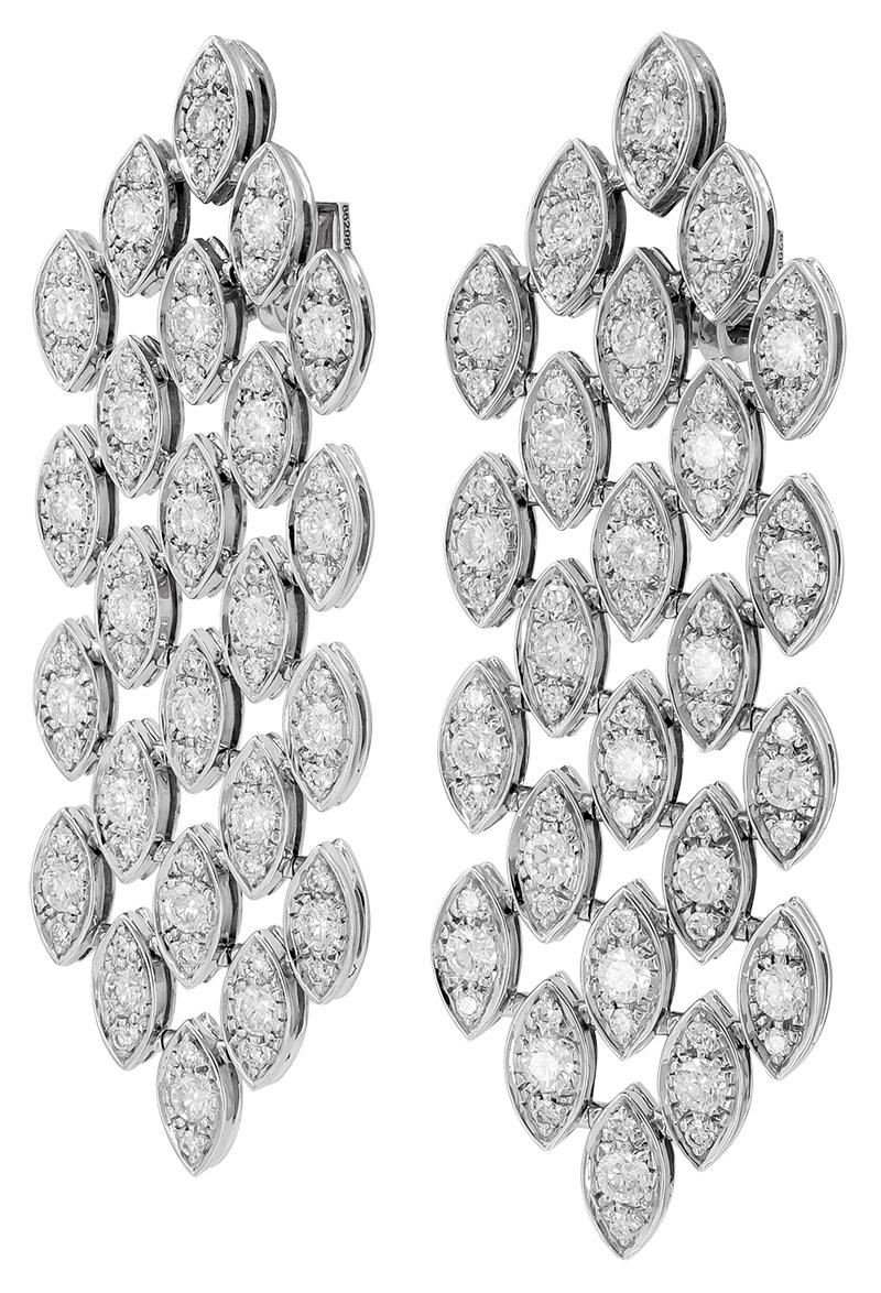 A pair of 18k gold earrings design as five rows of navette-shaped links, set with brilliant-cut diamonds, signed Cartier, French hallmarks.
Dimensions approx. 2 1/2″ x 3/4″