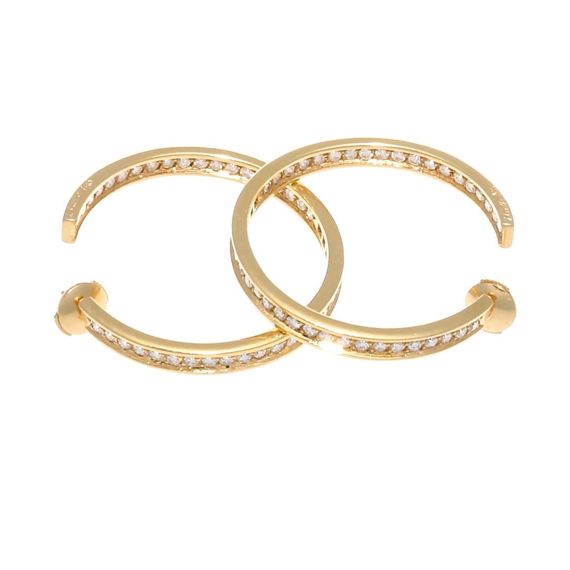 Cartier embodies women's prowess and femininity through elegant fashion. These iconic, graceful earrings would qualify as a must have accessory. Designed with swooping lines of glistening 18k yellow gold that is filled with colorless diamonds inside