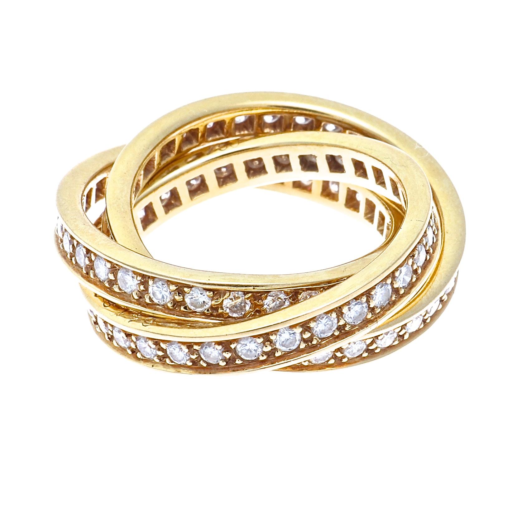 Cartier, elegant and timeless. A modern rendition of the trinity ring that has been part of the Cartier family since 1924. Featuring orbiting diamond gold eternity bands interlocking together with intrinsic meaning. Signed Cartier, numbered and