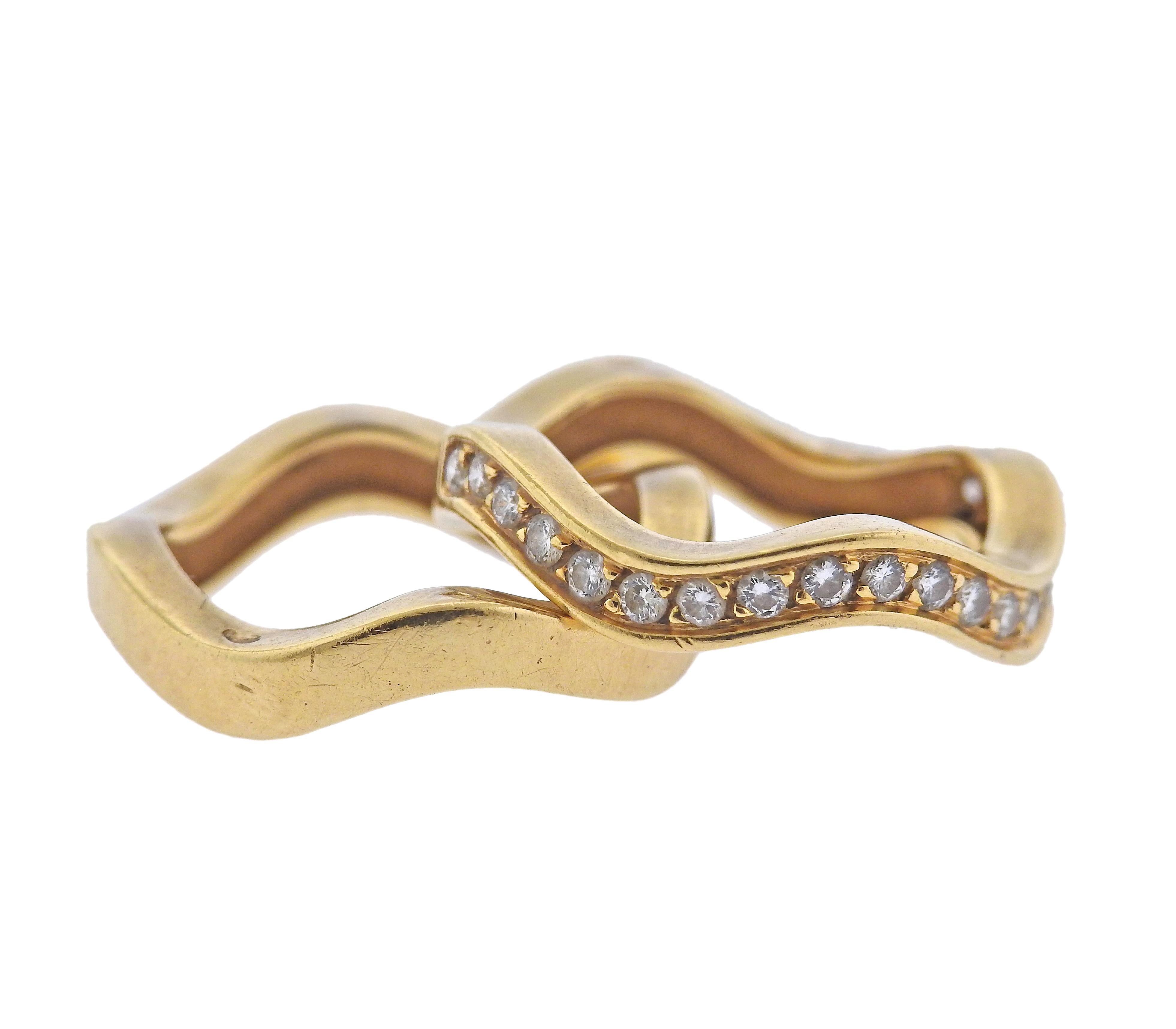 Set of two wave 18k gold band rings by Cartier, one set with approx. 0.38ctw G/VS in diamonds. Ring sizes - 5.25 each, each band is 3mm wide. Marked with French marks, 750, Cartier. Weight - 9.7 grams.
