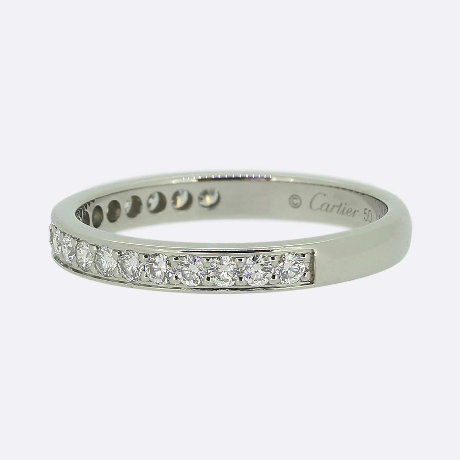 Here we have a classically styled diamond half-eternity ring from the world renowned luxury jewellery house of Cartier. This platinum piece features 19 round brilliant cut diamonds in a single line formation; all which have been individually claw