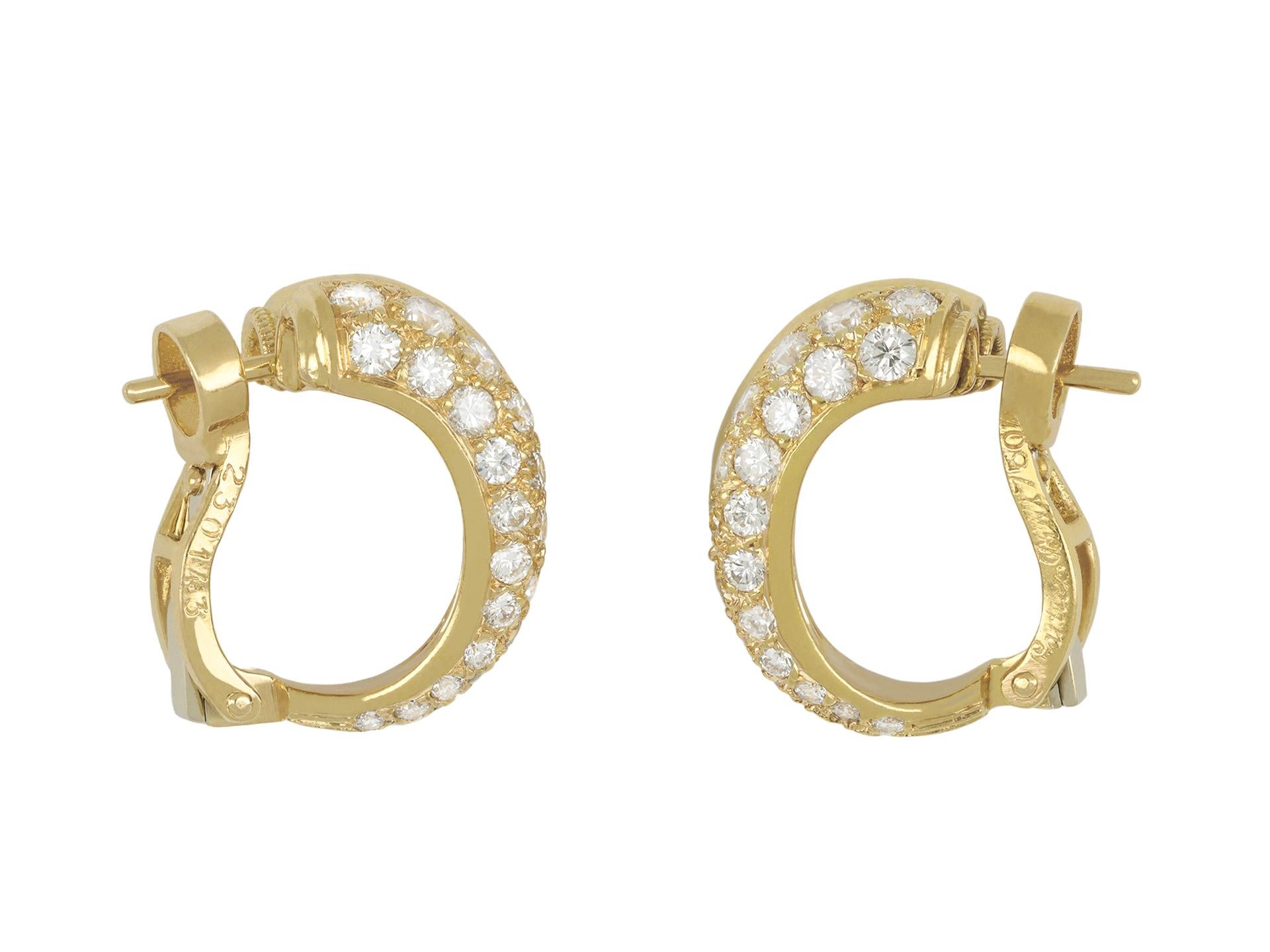 Cartier diamond hoop earrings. A matching pair, each set with thirty round transitional cut diamonds, sixty in total in open back grain settings, with a combined approximate weight of 1.40 carats, to a double hoop design featuring polished metalwork