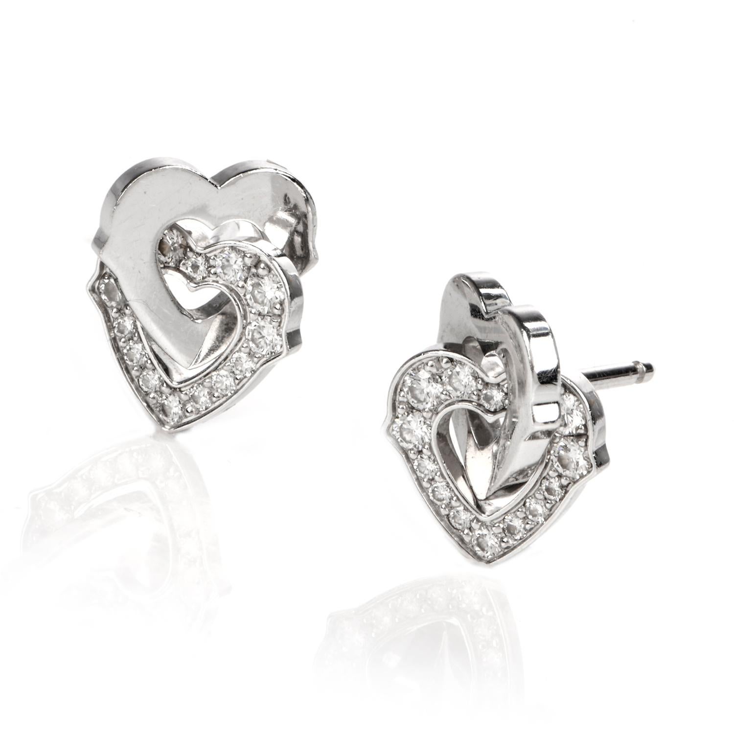 These charming Cartier diamond interlocking heart stud earrings are crafted in 18-karat white gold. Composed of two pairs of white gold open hearts interlocked with two pairs of pave-set round-cut diamond swathed open hearts. Diamonds collectively