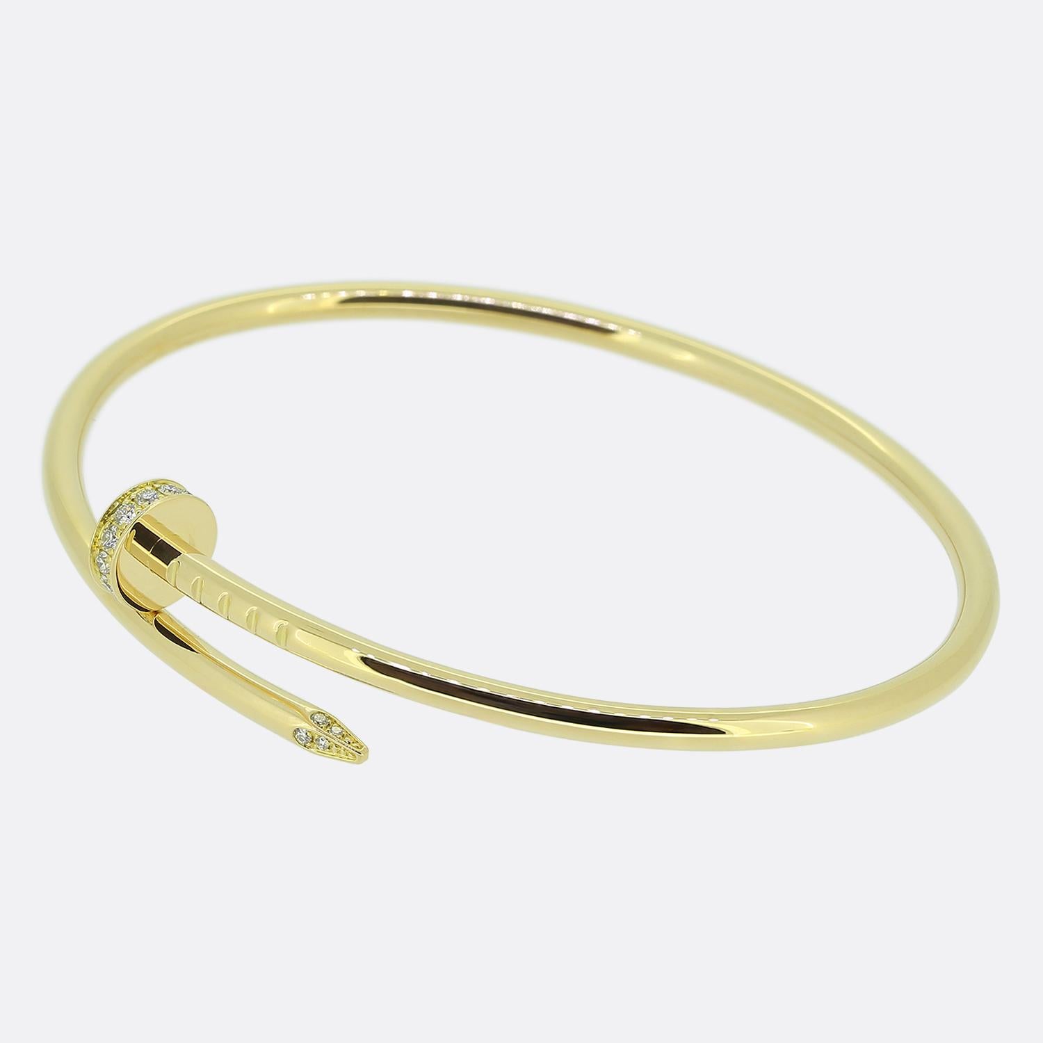 Here we have an 18ct yellow gold bracelet from the world renowned luxury jewellery house of Cartier. This piece forms part of their iconic Juste un Clou collection and showcases a wrap around nail design with a diamond set head and tip. This is the