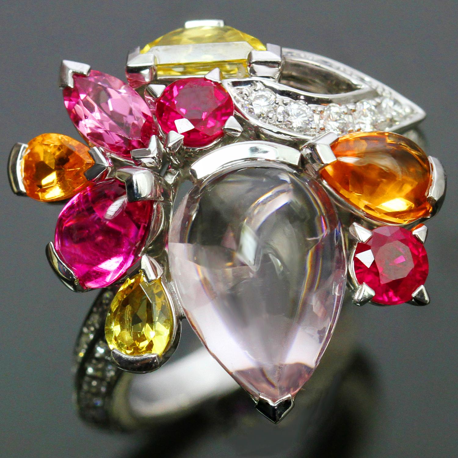 This fantastic Cartier ring is crafted in 18k white gold and features a vibrant cluster of colorful gemstones - red rubies, yellow sapphires, tourmaline, and rose quartz - accented with brilliant-cut round diamonds. Made in France circa 2010s.