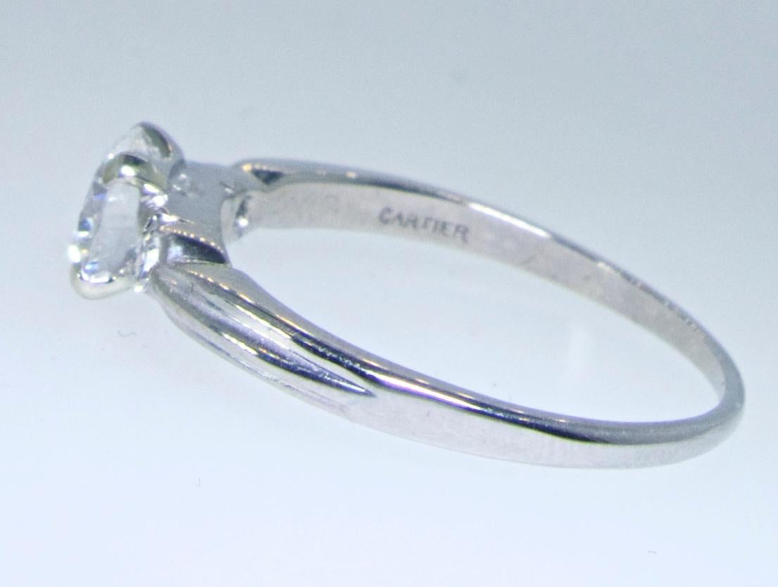 Vintage Cartier diamond ring possessing a center European cut diamond of fine proportions, near colorless,H/I, and very slightly included.  This diamond is estimated to weigh at least .58 cts.  There are two accent diamonds down the shank, bringing
