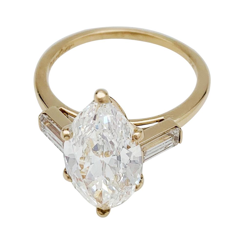 An 18kt yellow gold Cartier ring, centered with a 3.15 carats marquise shaped diamond, E colour, VVS 2 clarity, shouldered with baguette cut diamonds.
French laboratory certificate (2019).
Signed Cartier and numbered.
Ring size : 6.5 can be sized