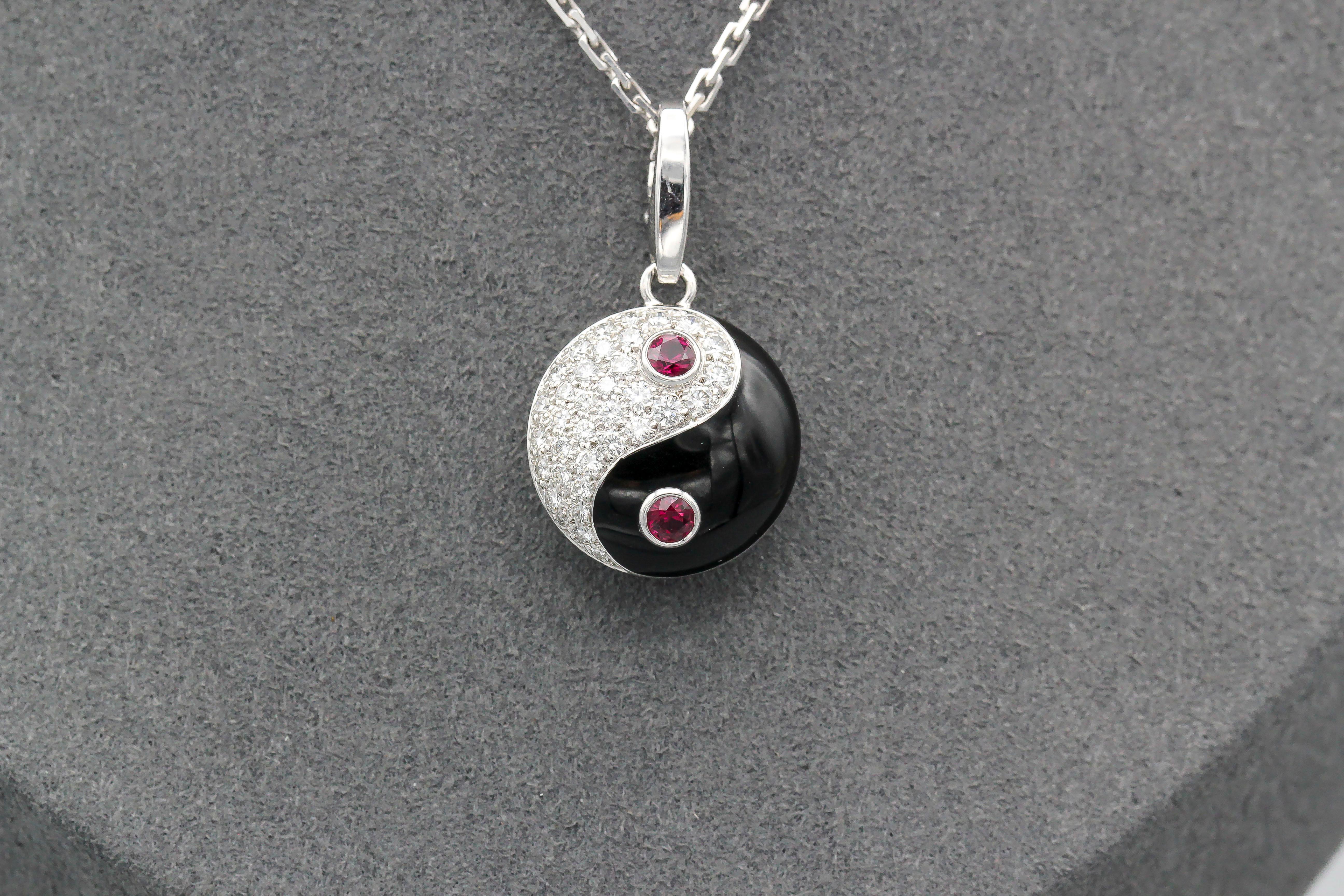 Fine ruby diamond and 18K white gold charm by Cartier. Designed as the Yin Yang sign, it features diamonds and rubies.  Well made and easy to add to any bracelet or pendant.  Chain not included.

Hallmarks: Cartier, 750, reference numbers, French