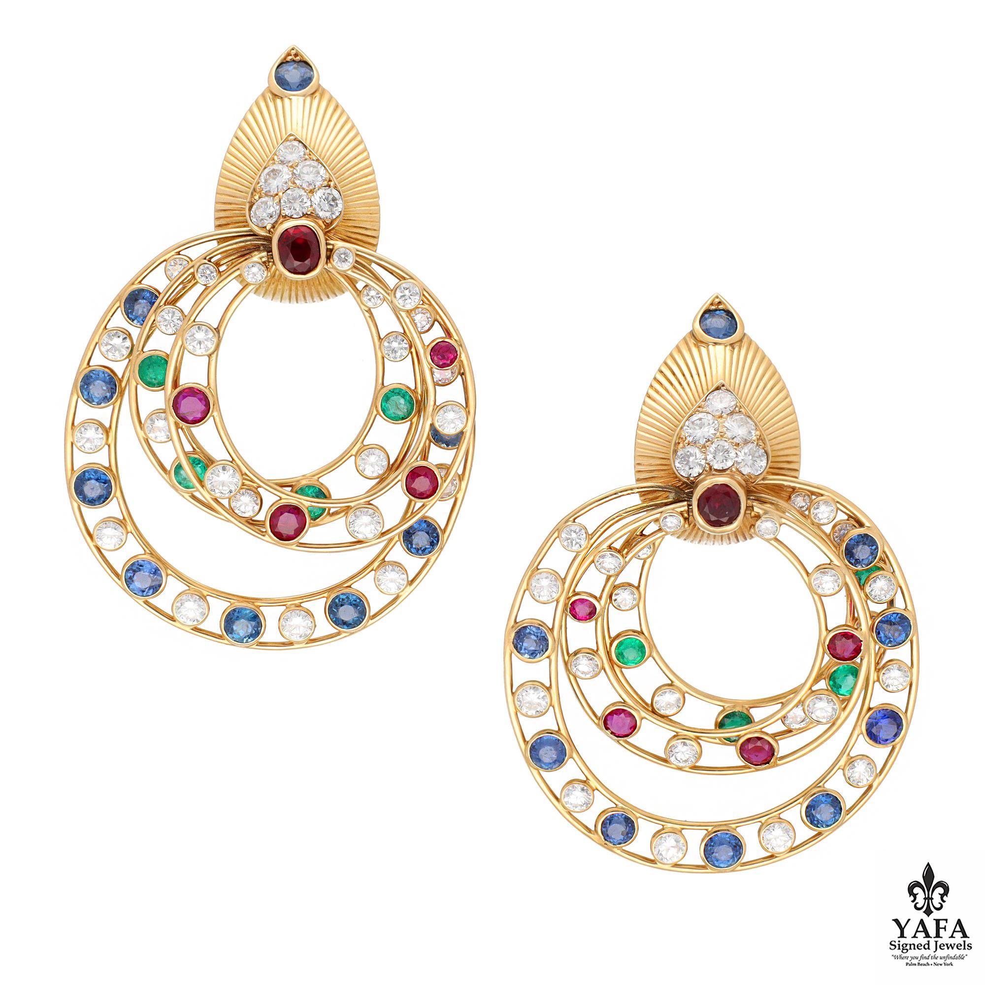 18K yellow gold earrings featuring three hoops of different sizes, each containing Diamonds, Sapphires, Rubies, and Emeralds suspended from a pear-shaped fluted gold top. The top is adorned with a single Ruby, five round brilliant diamonds, and it