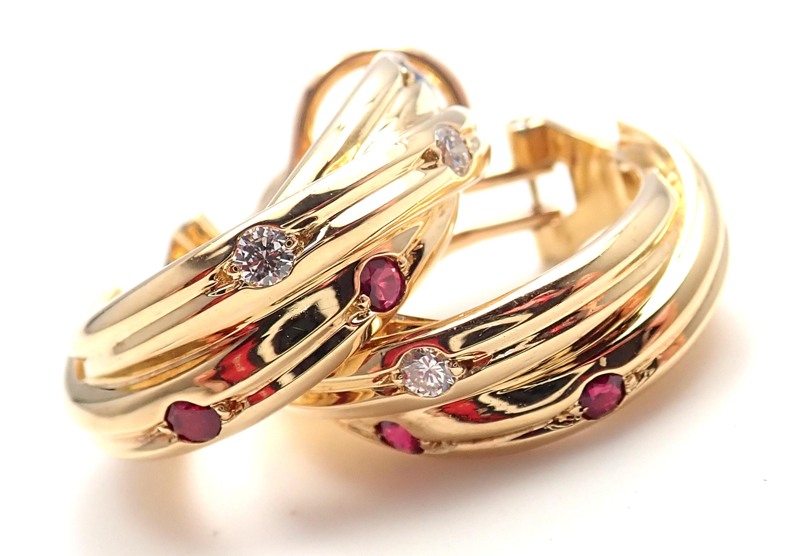 18k Yellow Gold Trinity Diamonds Sapphires Rubies Hoop Earrings by Cartier.
With 4 round brilliant cut diamonds total weigt approx. .16ct
4 rubies, 2 sapphires
These earrings are for pierced ears.
Details: 
Measurements 22mm x 7mm	
Weight: 14.1