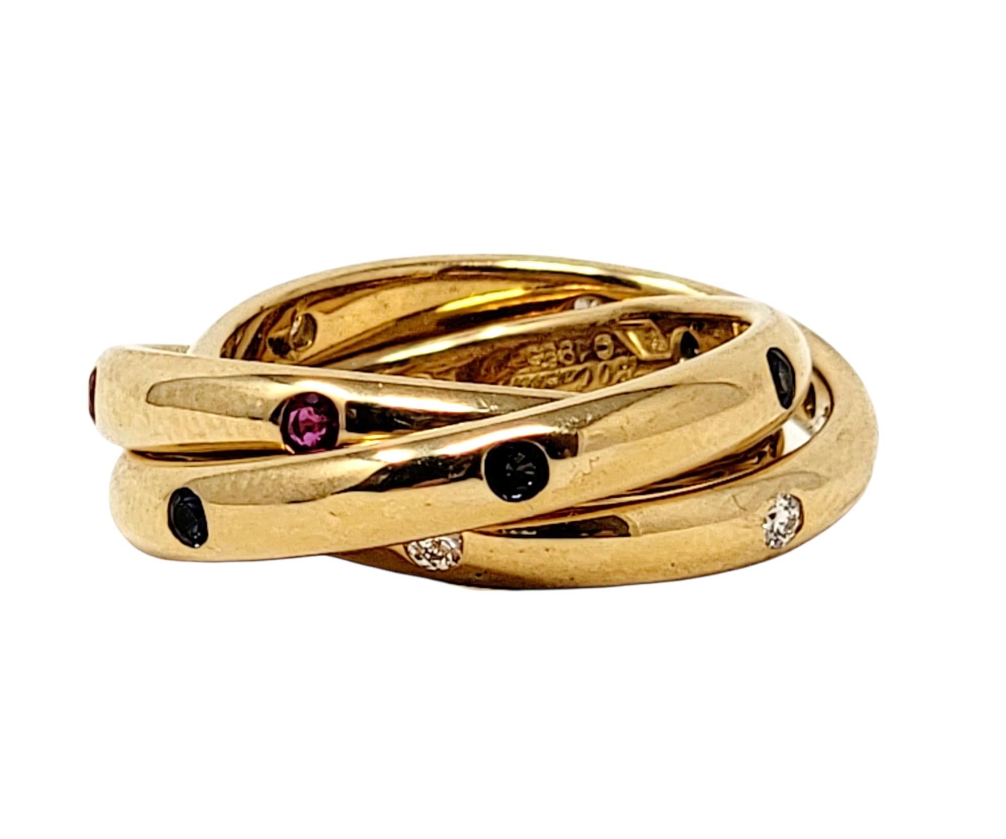 Ring size: 4.5

Stunning Cartier Trinity multi band ring with diamonds, rubies and sapphires. The three interlaced yellow gold  bands symbolize love, fidelity and friendship. Though there are 3 individual bands, the trio is attached and meant to be