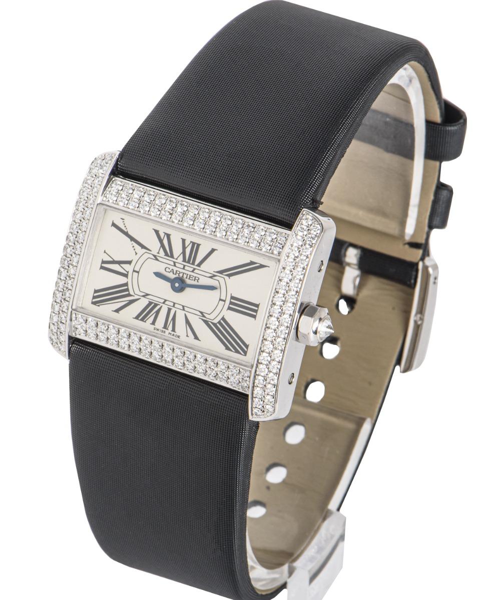 From Cartier's Tank Divan collection, 32mm,  this piece in white gold features a silver dial with Roman numerals, blued-steel sword-shaped hands and a secret Cartier signature at X.

The bezel is set with 102 round brilliant cut diamonds and to