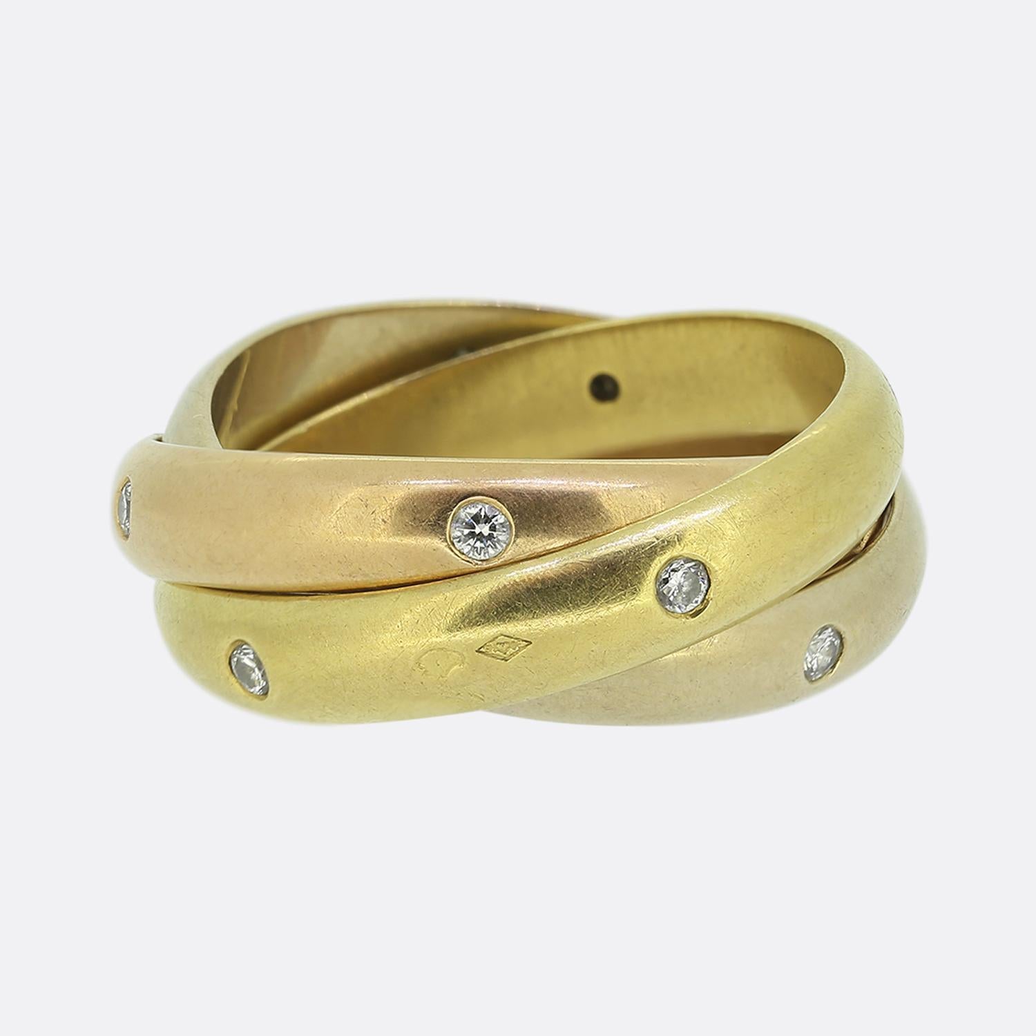 Here we have an 18ct gold diamond trinity ring from the world renowned luxury jewellery house of Cartier. This iconic piece features interwinding 18ct yellow, rose and white gold bands; each of which has been interspersed with five round brilliant