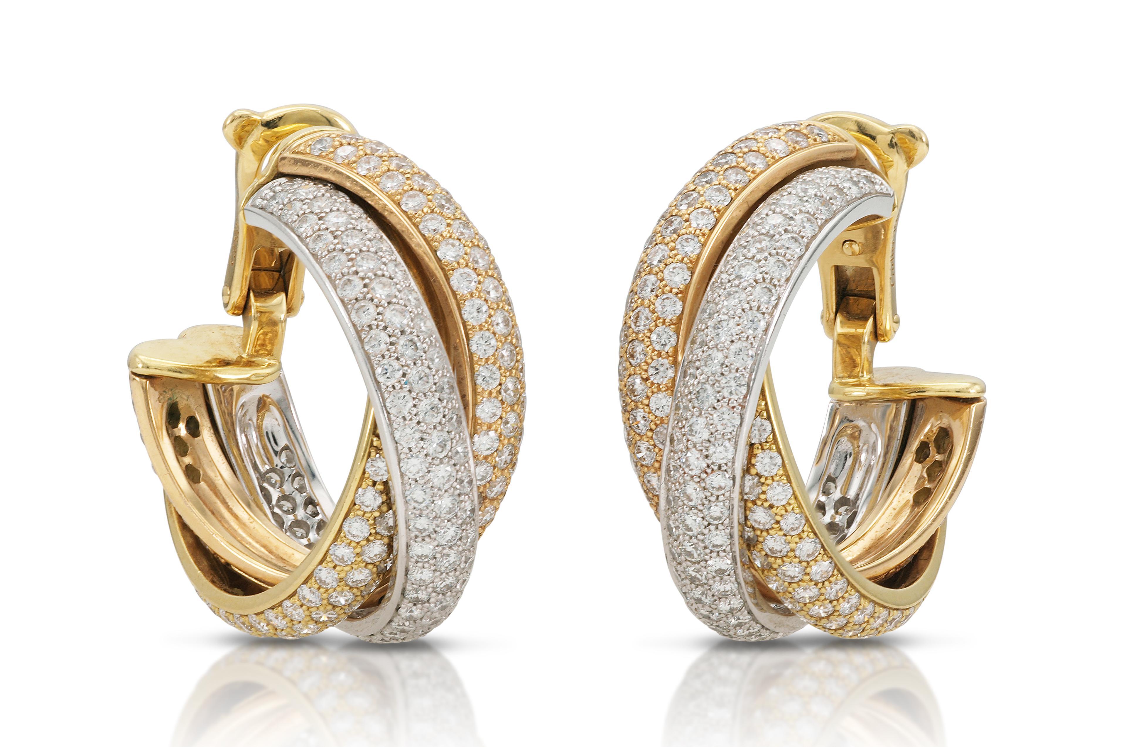 Finely crafted in 18k yellow, rose, and white gold with pave-set Round Brilliant cut Diamonds weighing approximately a total of 2.15 carats.
Signed by Cartier, from their Trinity collection.
7/8 inch diameter
Comes with its Certificate of