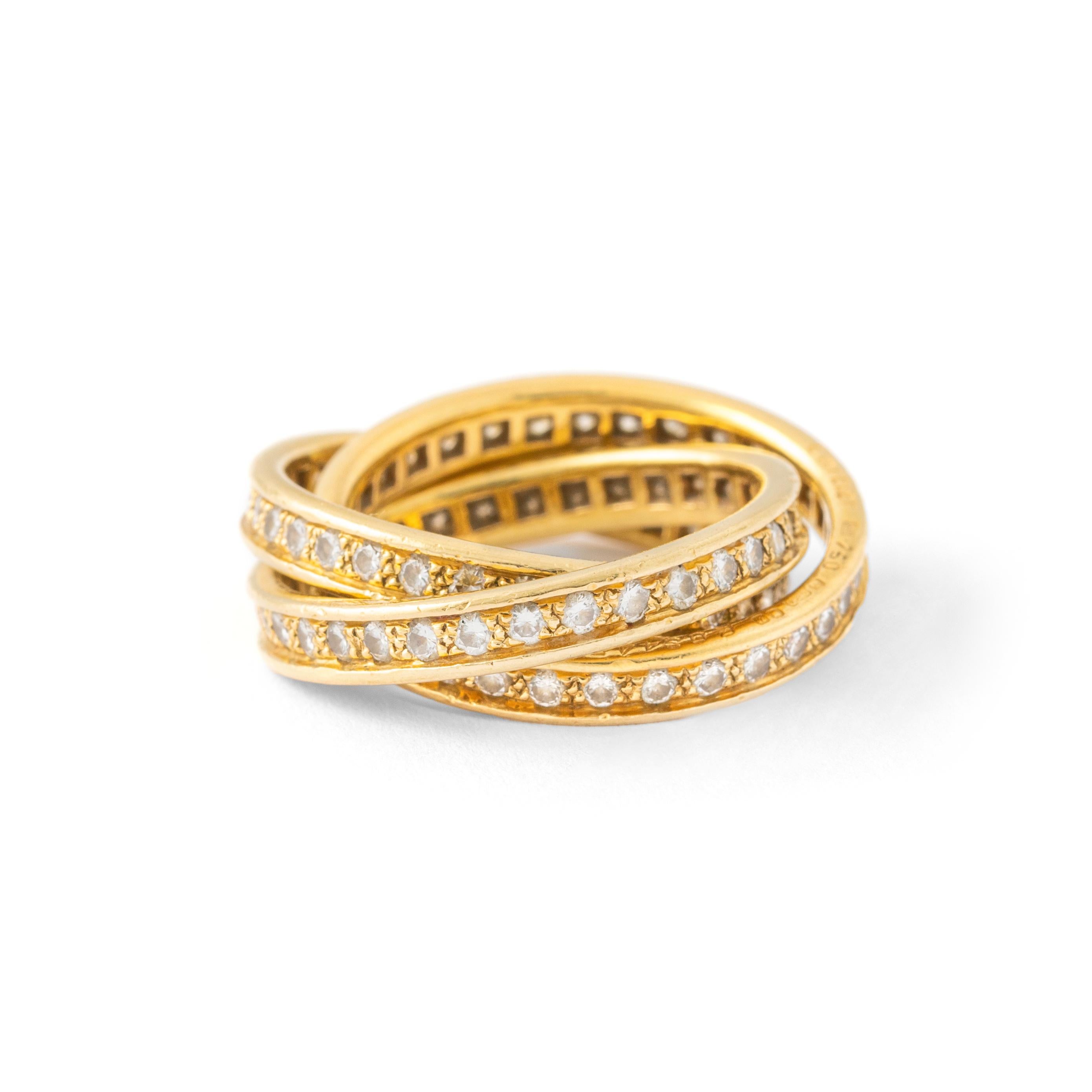 Gold Trinity ring set with brilliant cut diamonds. 
'Trinity', Cartier.
Interlocking movable intertwined yellow gold 18K bands, brilliant-cut diamonds, signed Cartier, numbered, French maker's and assay marks for gold.

A true 