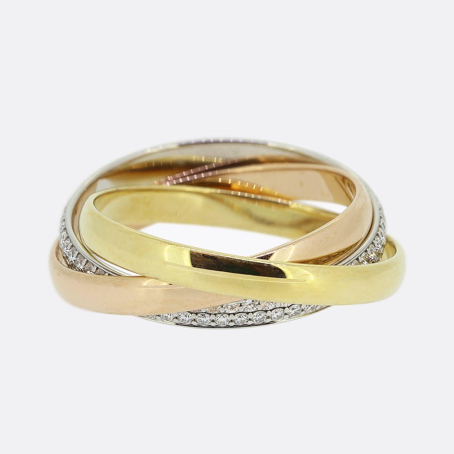 Here we have an 18ct gold diamond trinity ring from the world renowned luxury jewellery house of Cartier. The ring features interwinding 18ct yellow, rose and white gold bands; the white of which has been entirely pave set with two rows of round