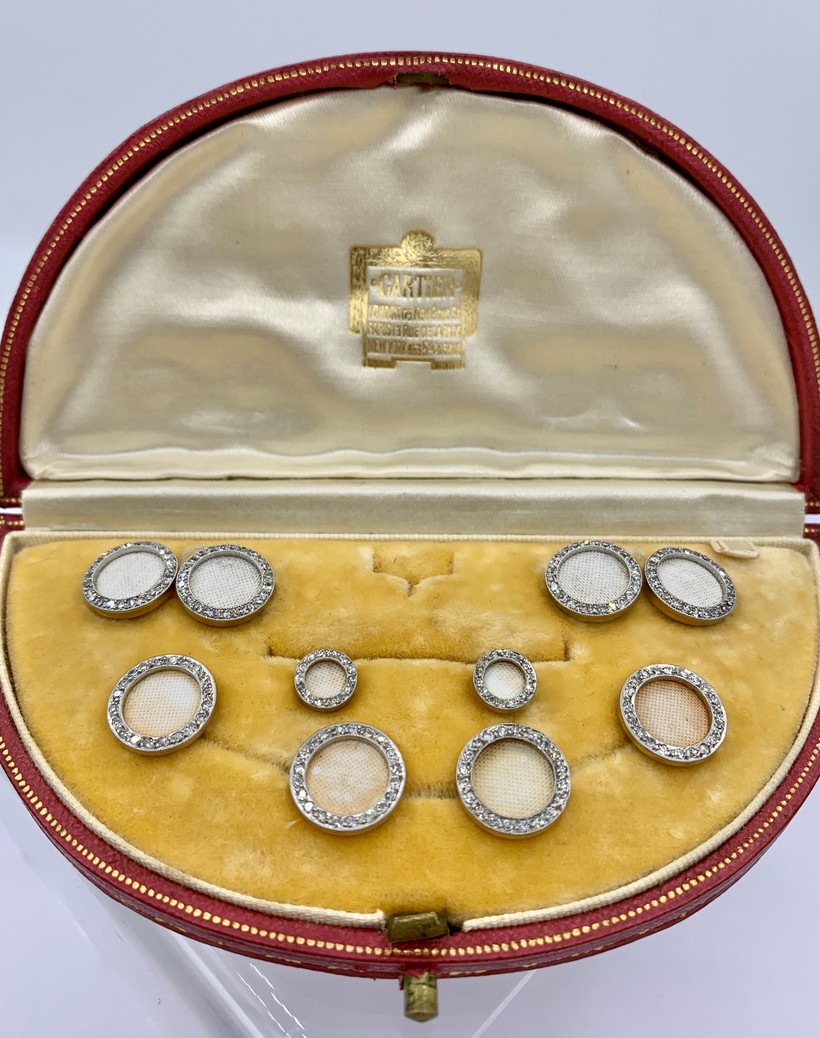 Il s'agit d'une extraordinaire parure de robe française Cartier en diamant et émail, avec boutons de manchette, clous d'oreilles et boutons en platine et or 18 carats, datant de la période Art Déco, vers 1910, dans son écrin d'origine en cuir rouge